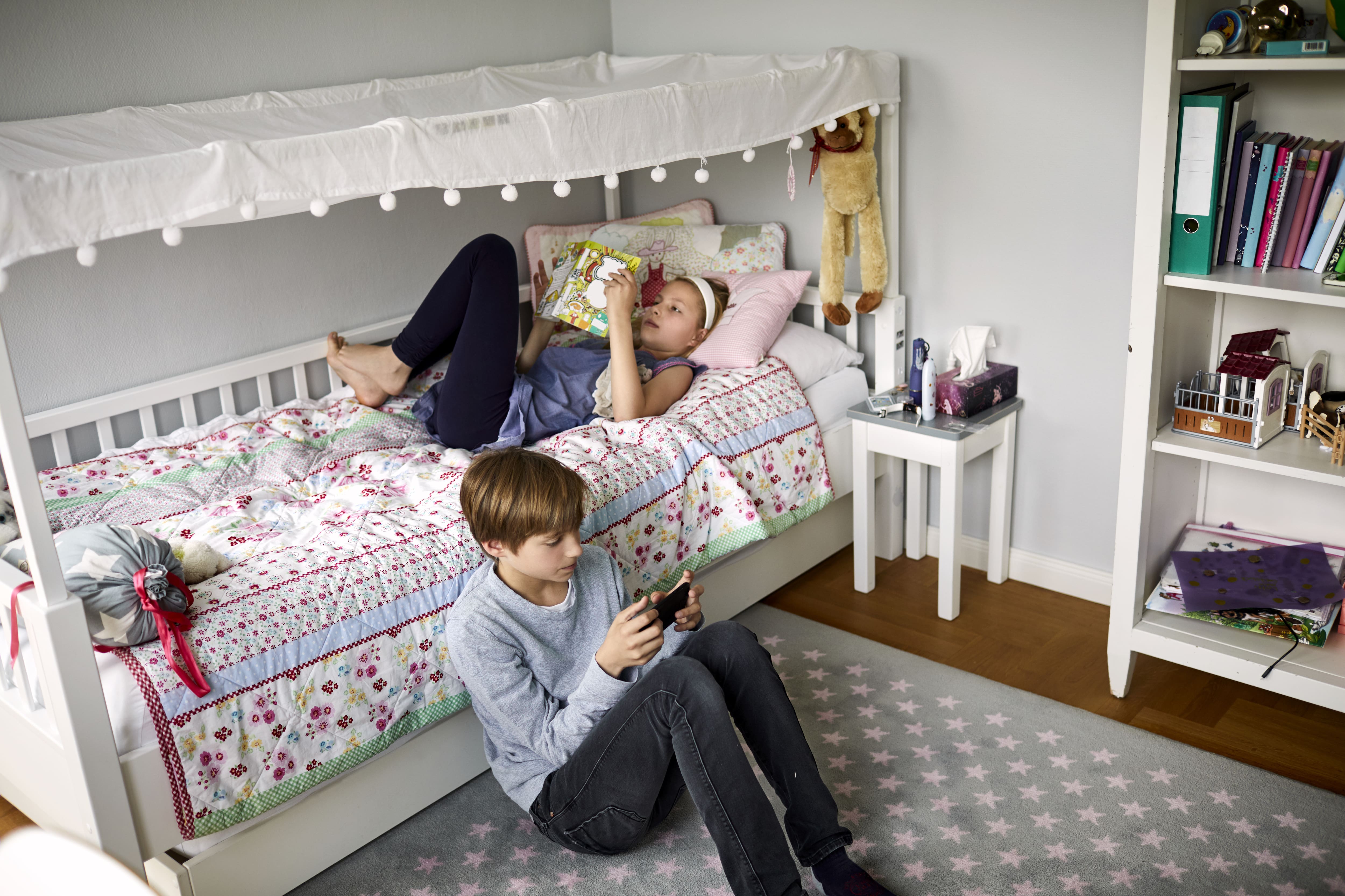 Brother and sister relaxing in room