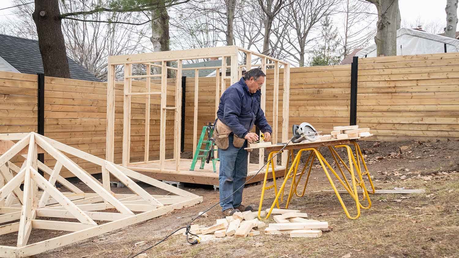 Carpenter building a new wooden shed in the yard