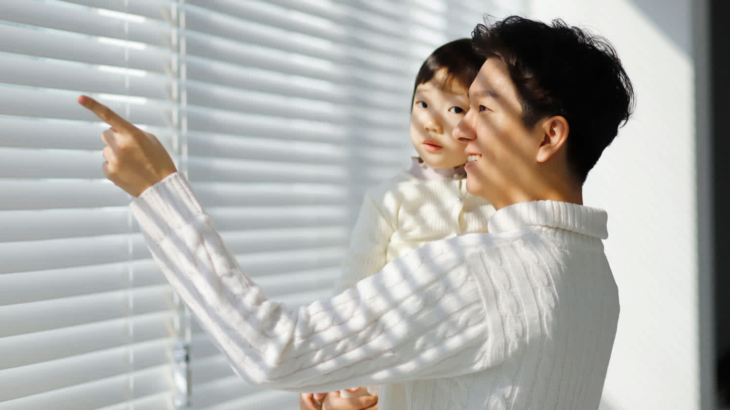 A father showing to his daughter the motorized blinds