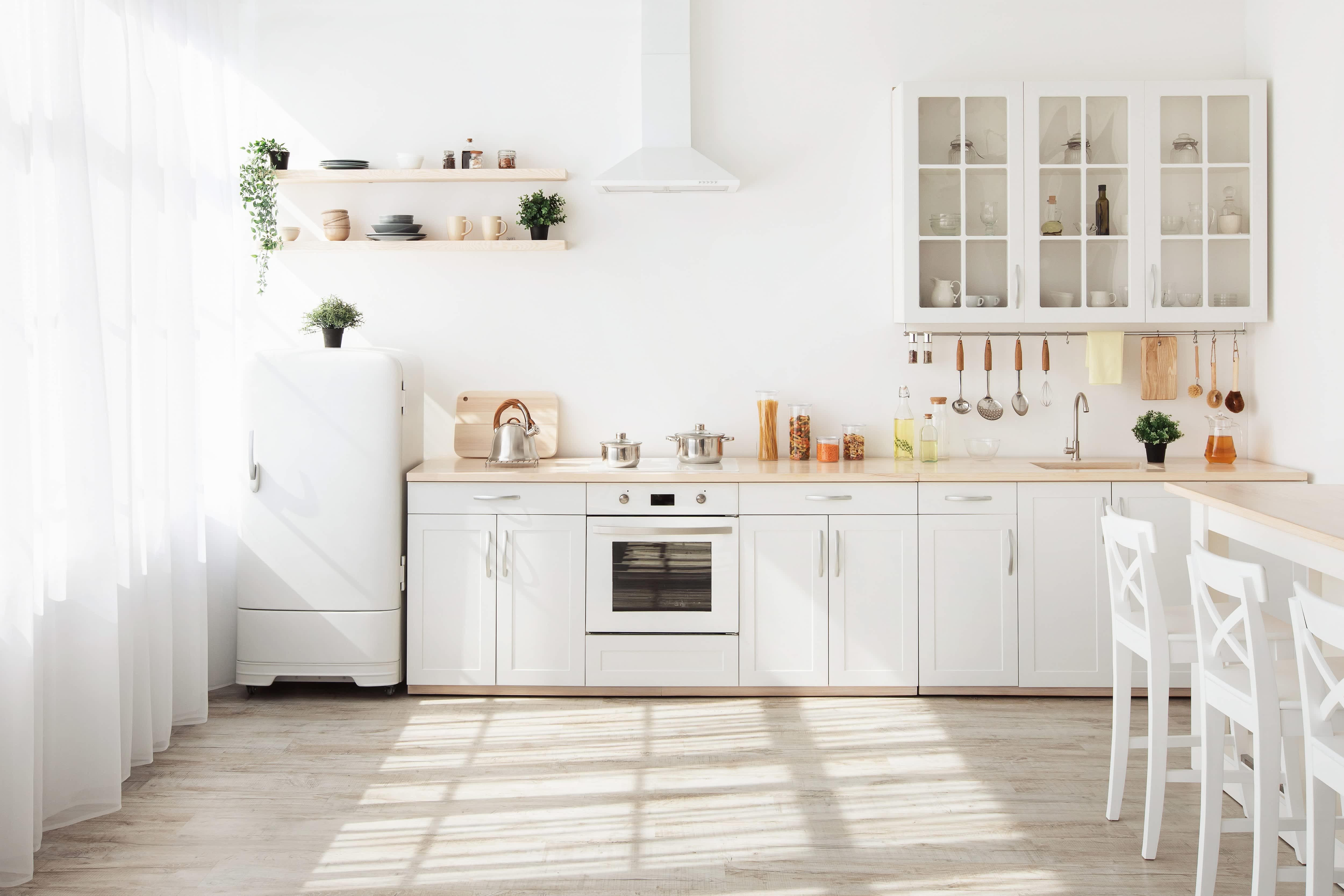 A small kitchen with white curtains and bar style seating