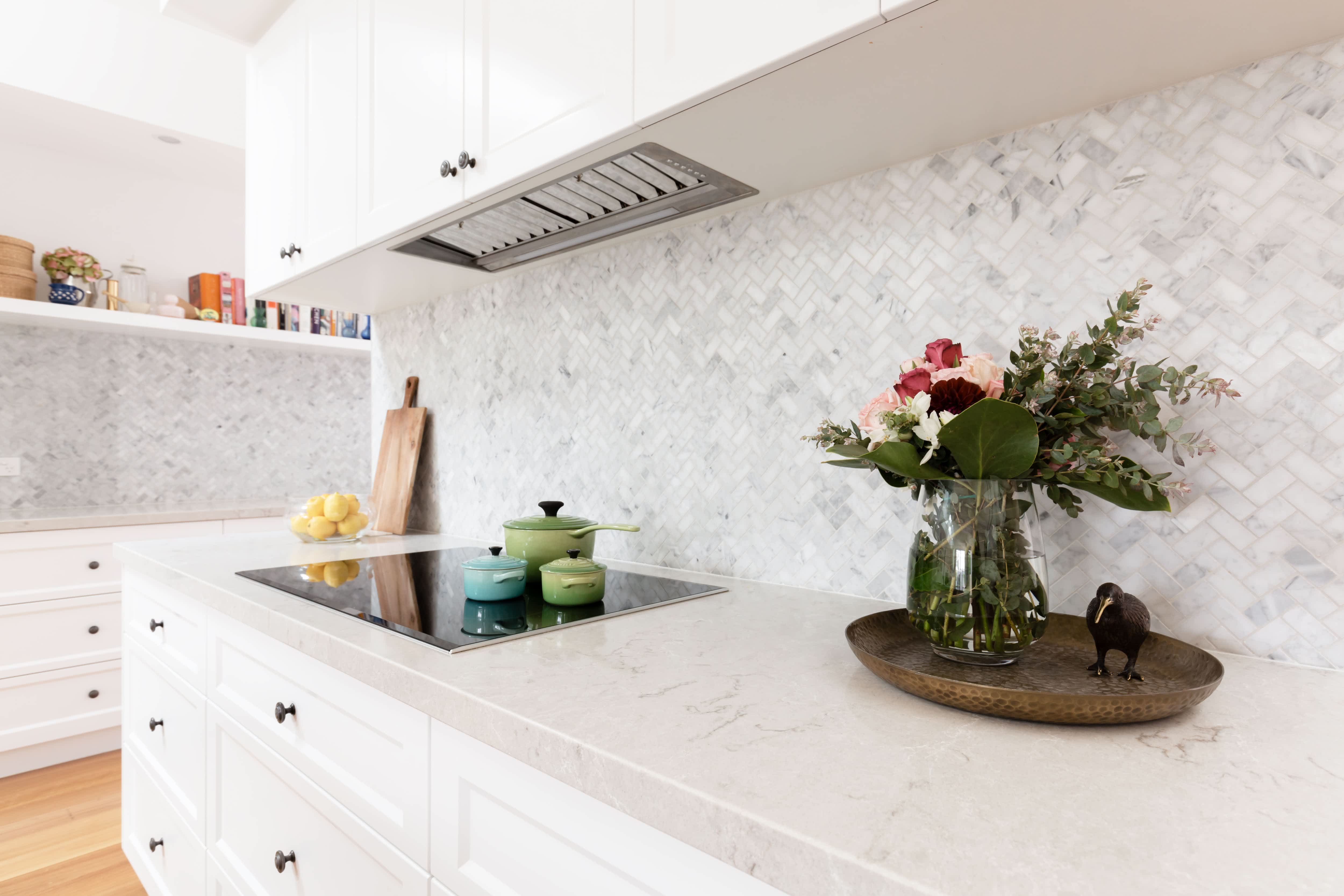 A long countertop with a gray herringbone pattern backsplash