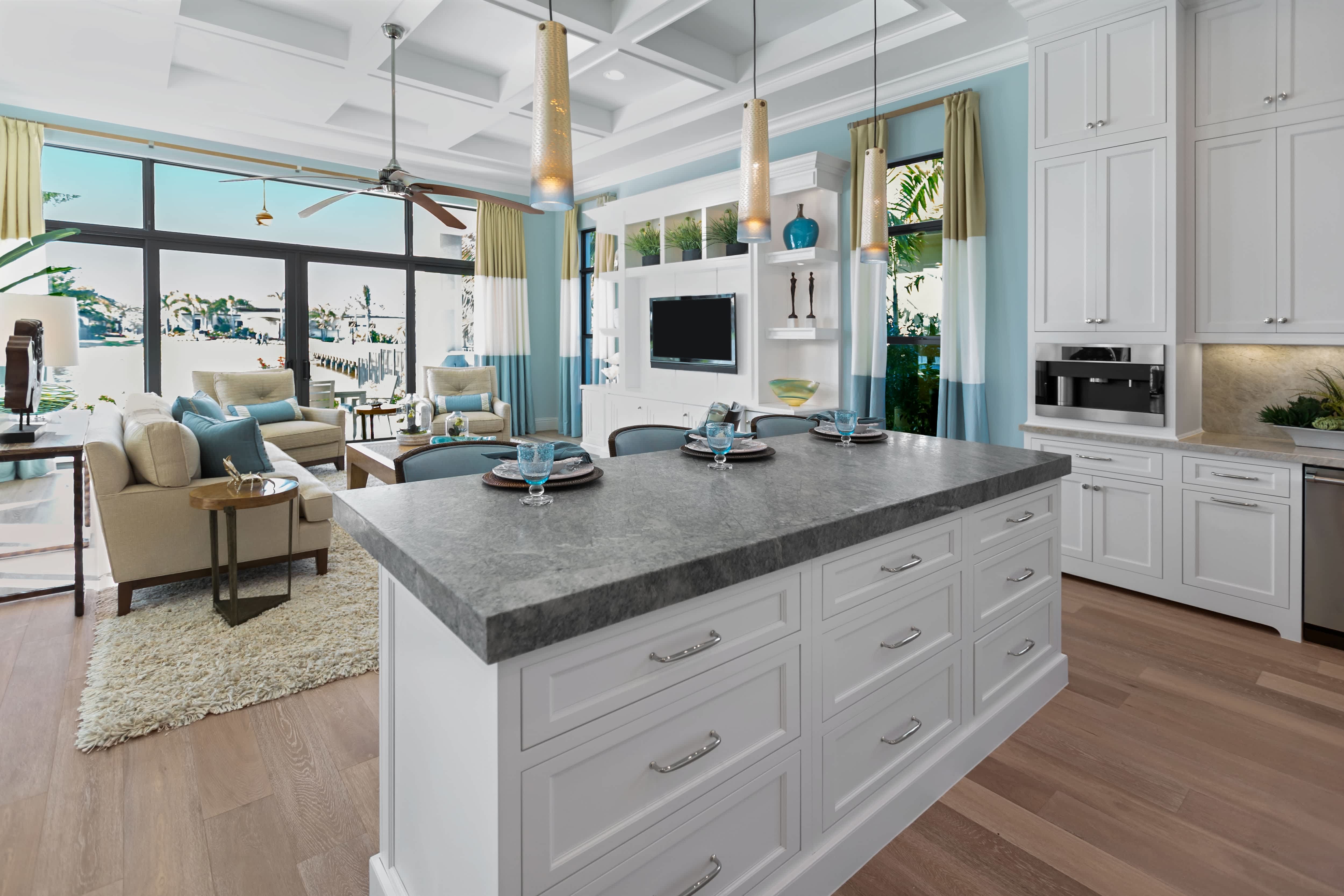 A spacious kitchen with a white island and matching chairs