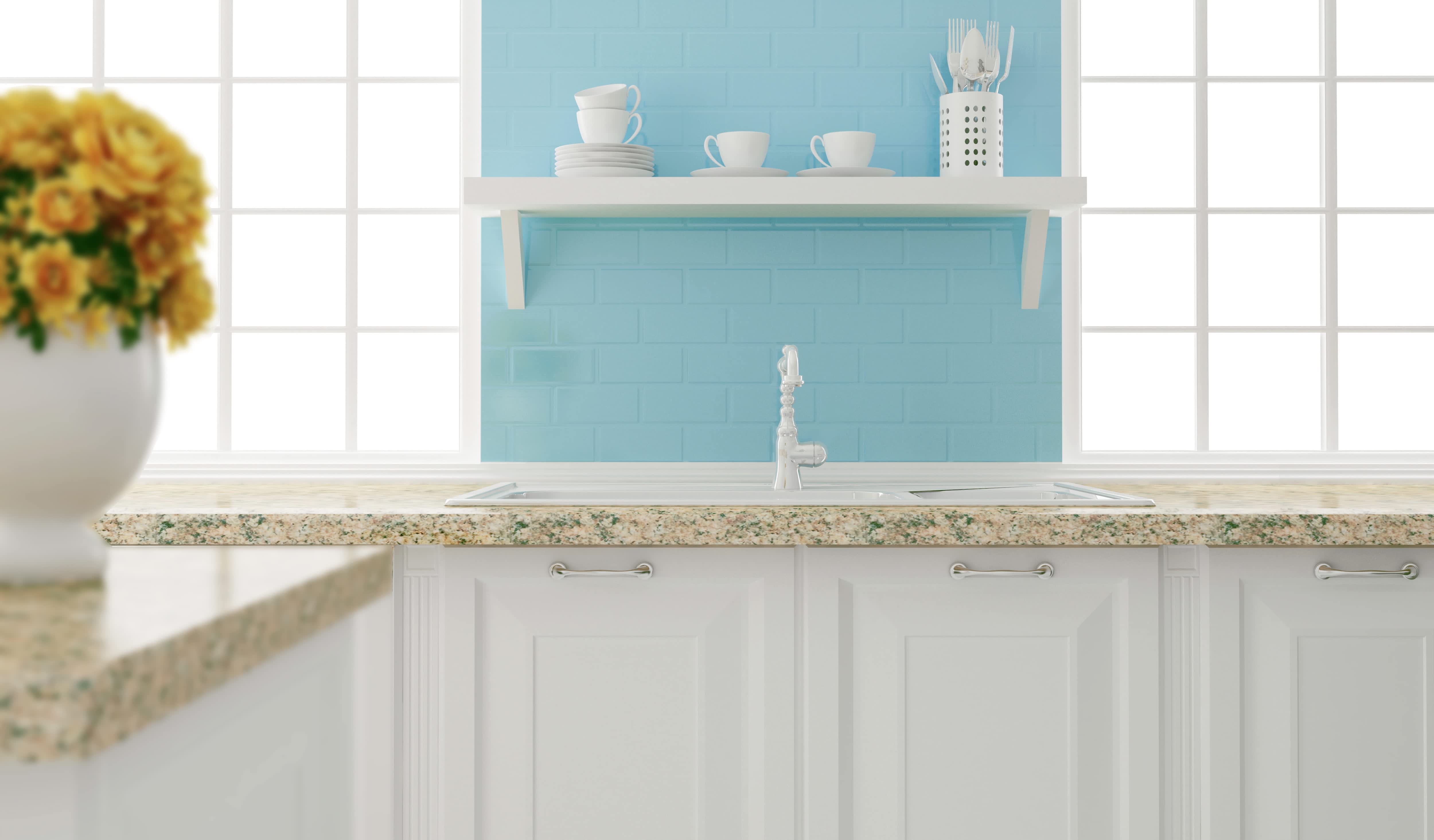 A white kitchen with a light blue backsplash and open shelving