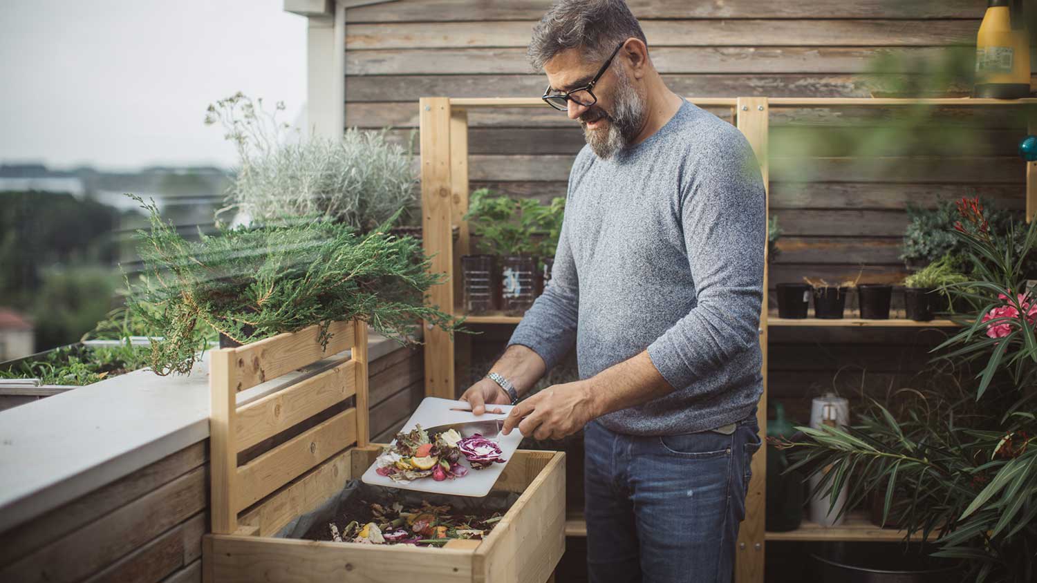 Man using food scraps to make compost
