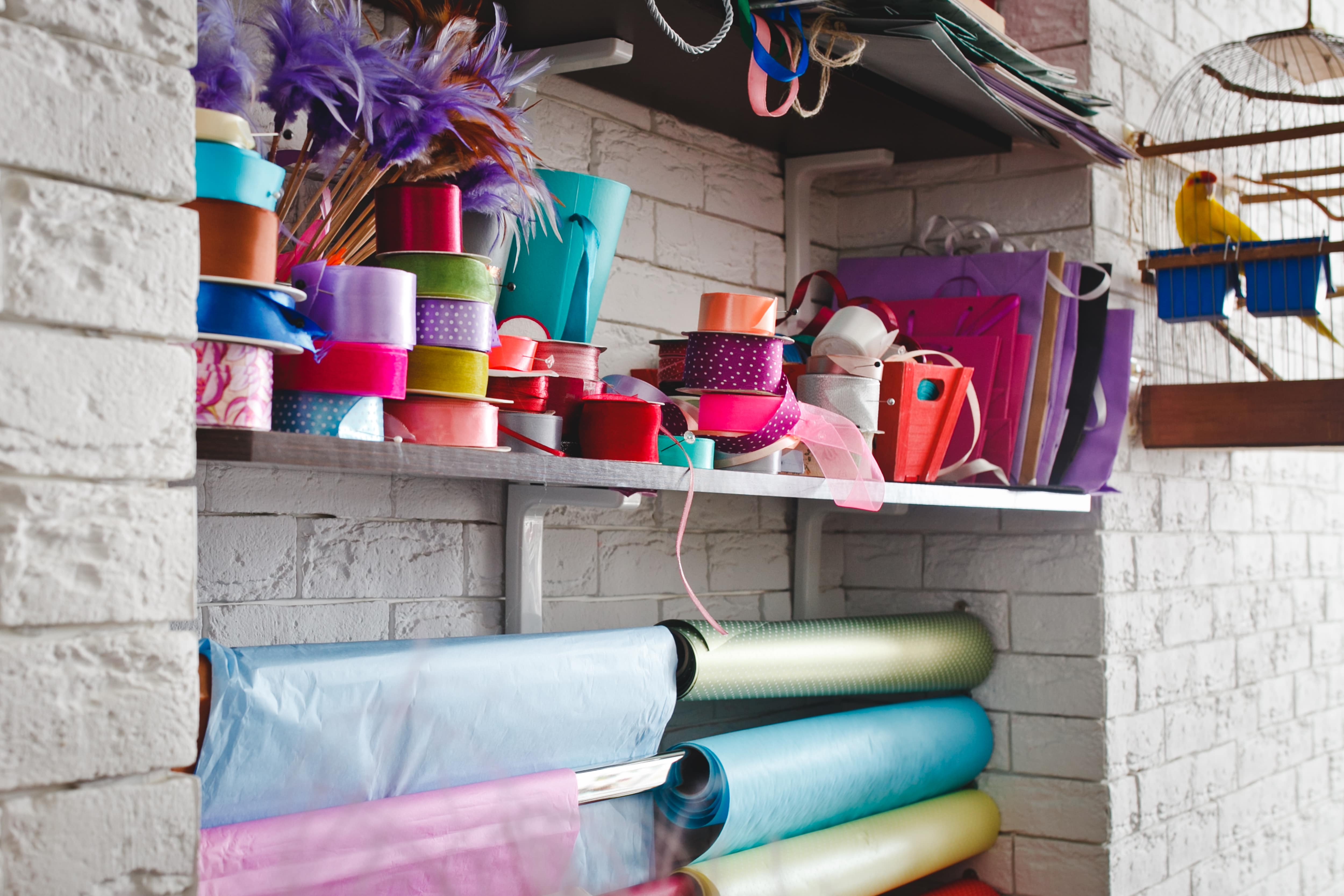 Craft room with ribbons and wrapping paper hanging on tension rods