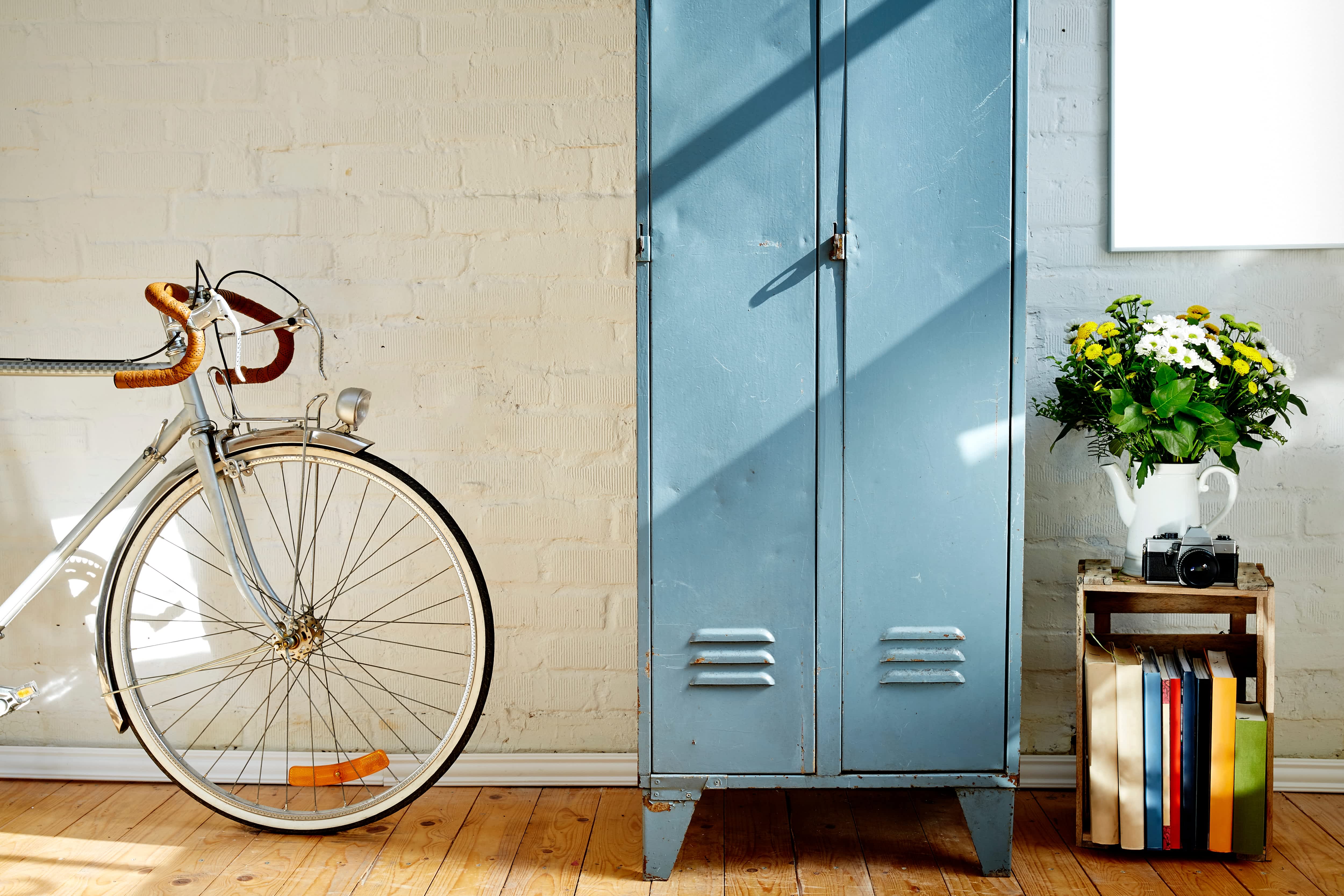 Vintage blue lockers in home next to books and a bike