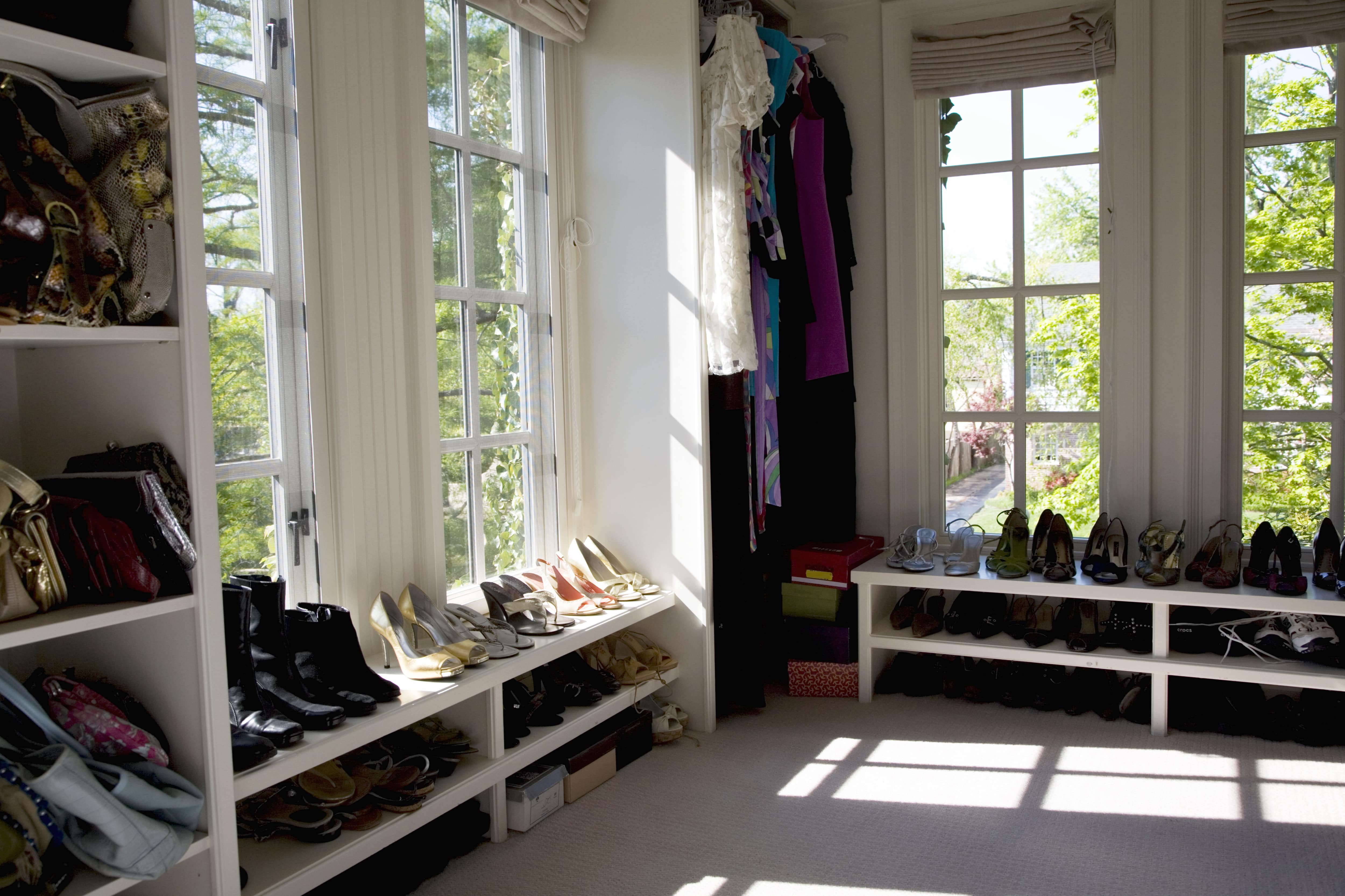 A side image of a walk-in closet with low level shelves holding shoes