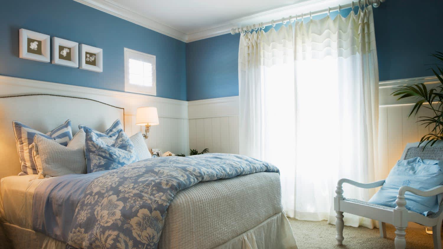 A cozy blue bedroom with flower linens