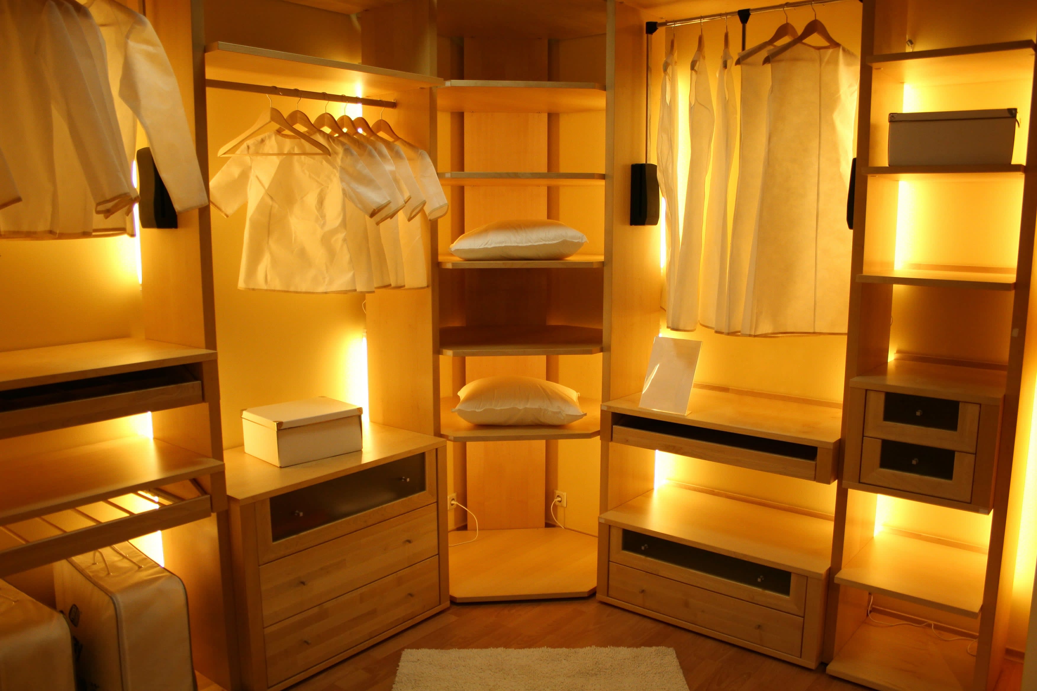 A warmly lit closet with interior shelf lights