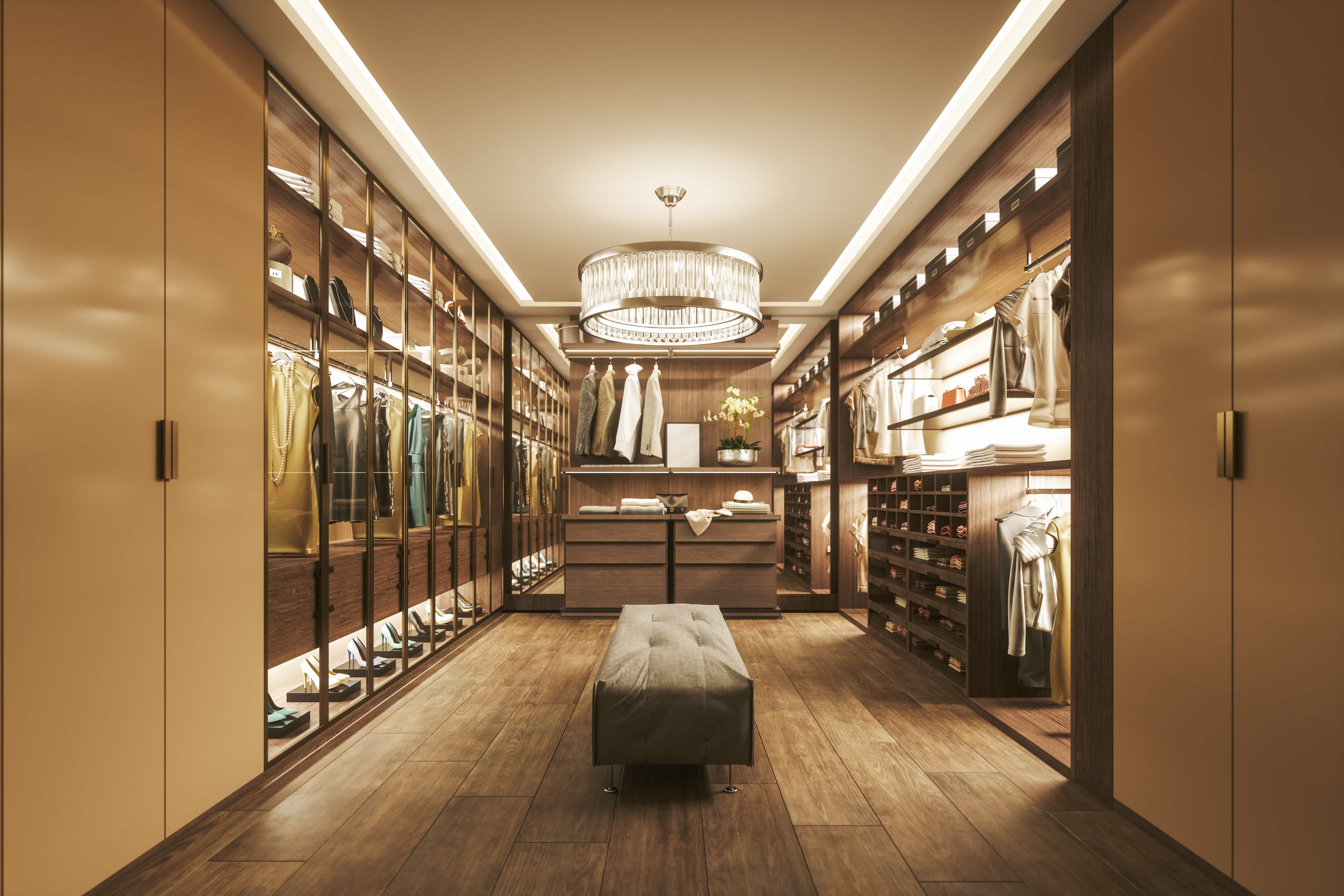 A long walk-in closet with a lit chandelier hanging from the ceiling
