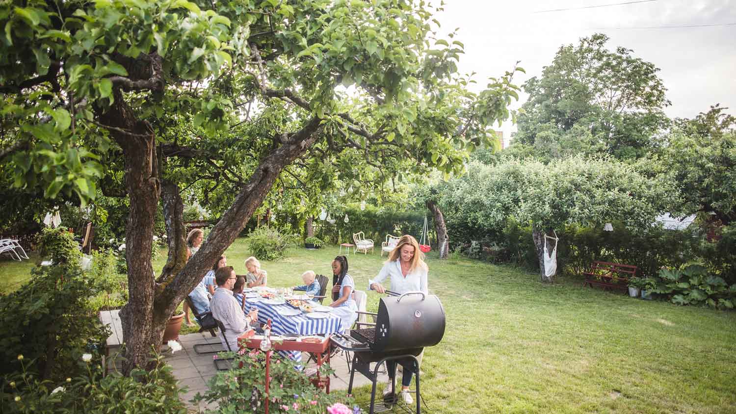 Woman in the backyard grilling food for the family