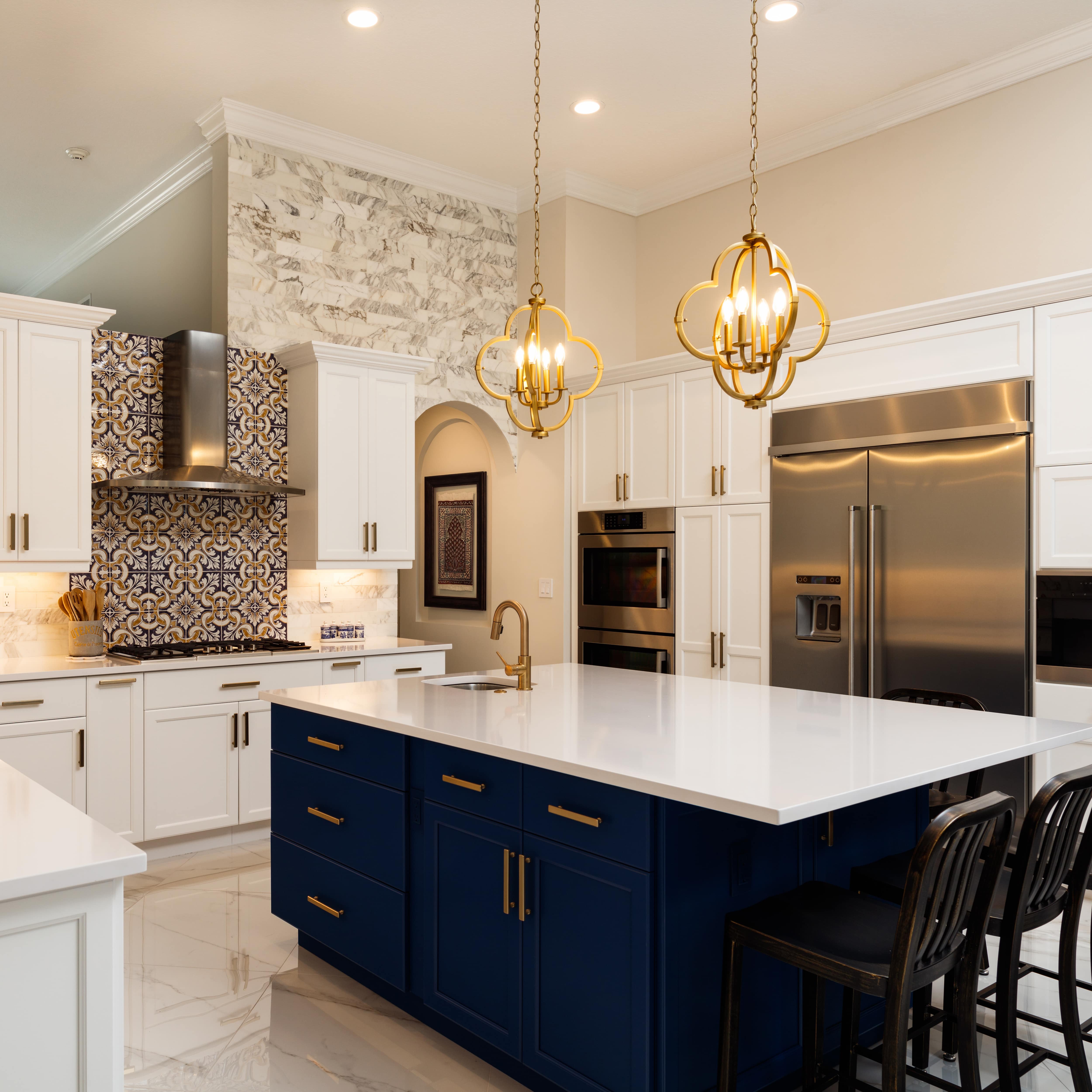 A statement range hood with a colorful backsplash in an white estate kitchen