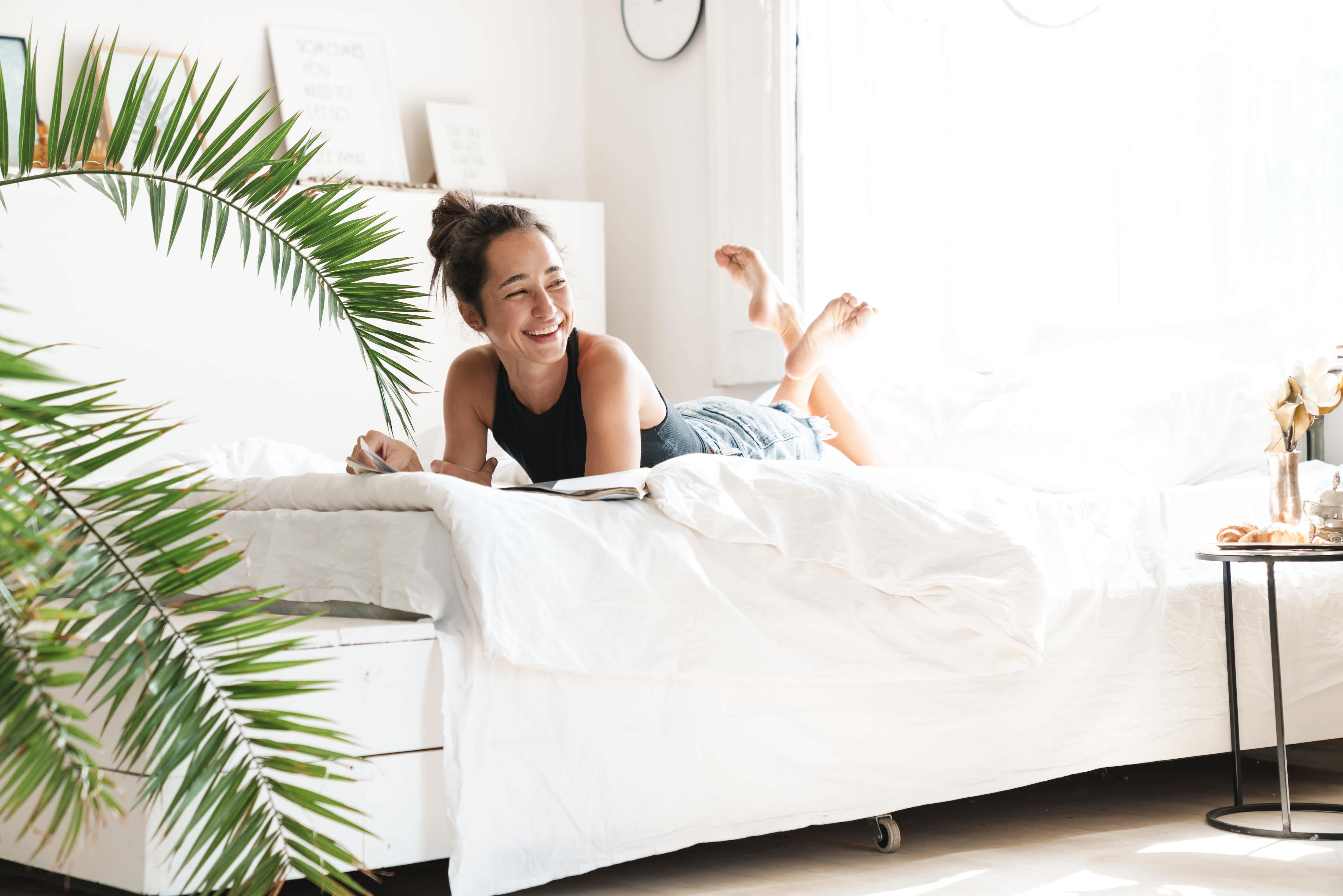 Woman sitting in bedroom reading a magazine