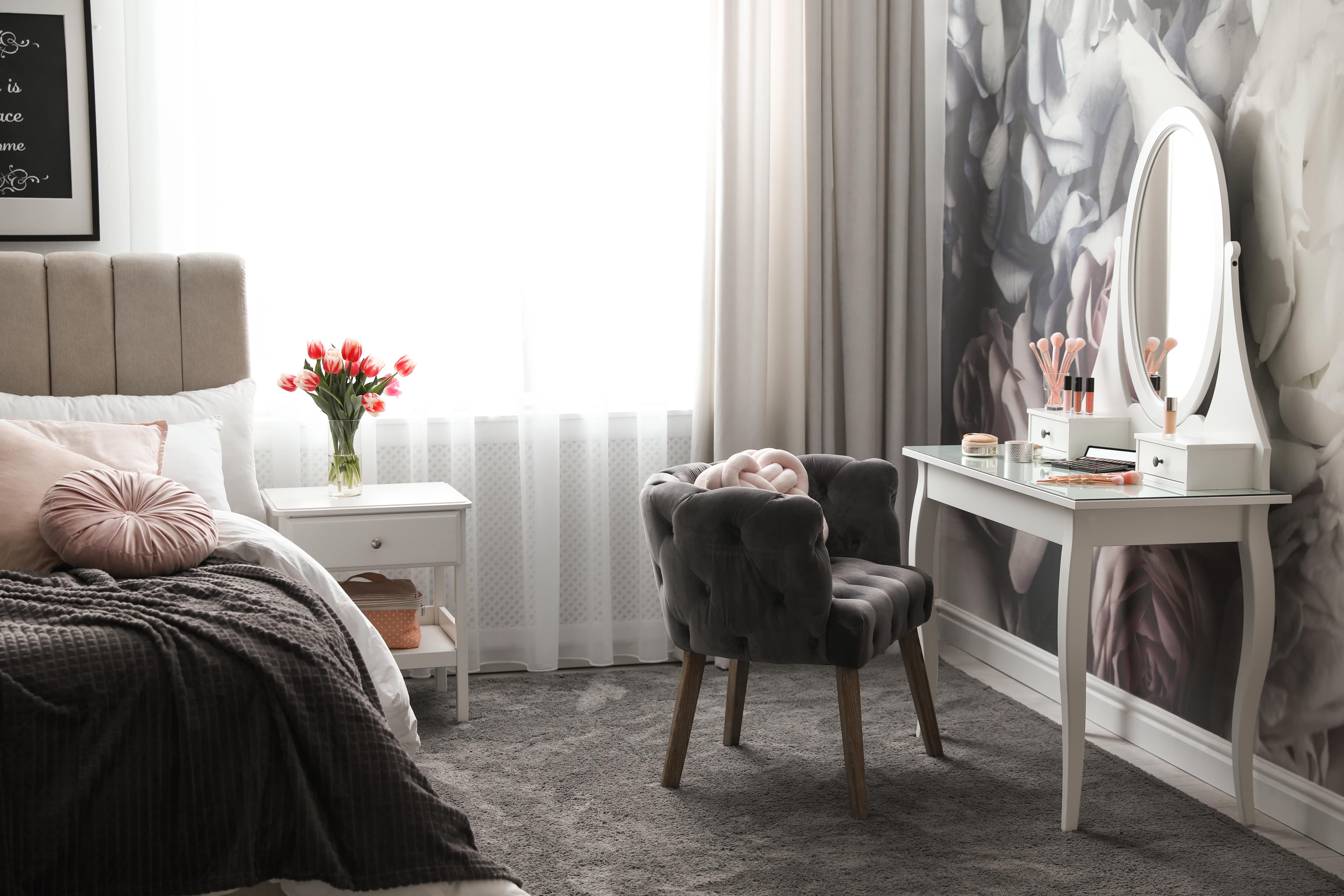 Elegant bedroom with a dressing table, mirror, and floral wallpaper