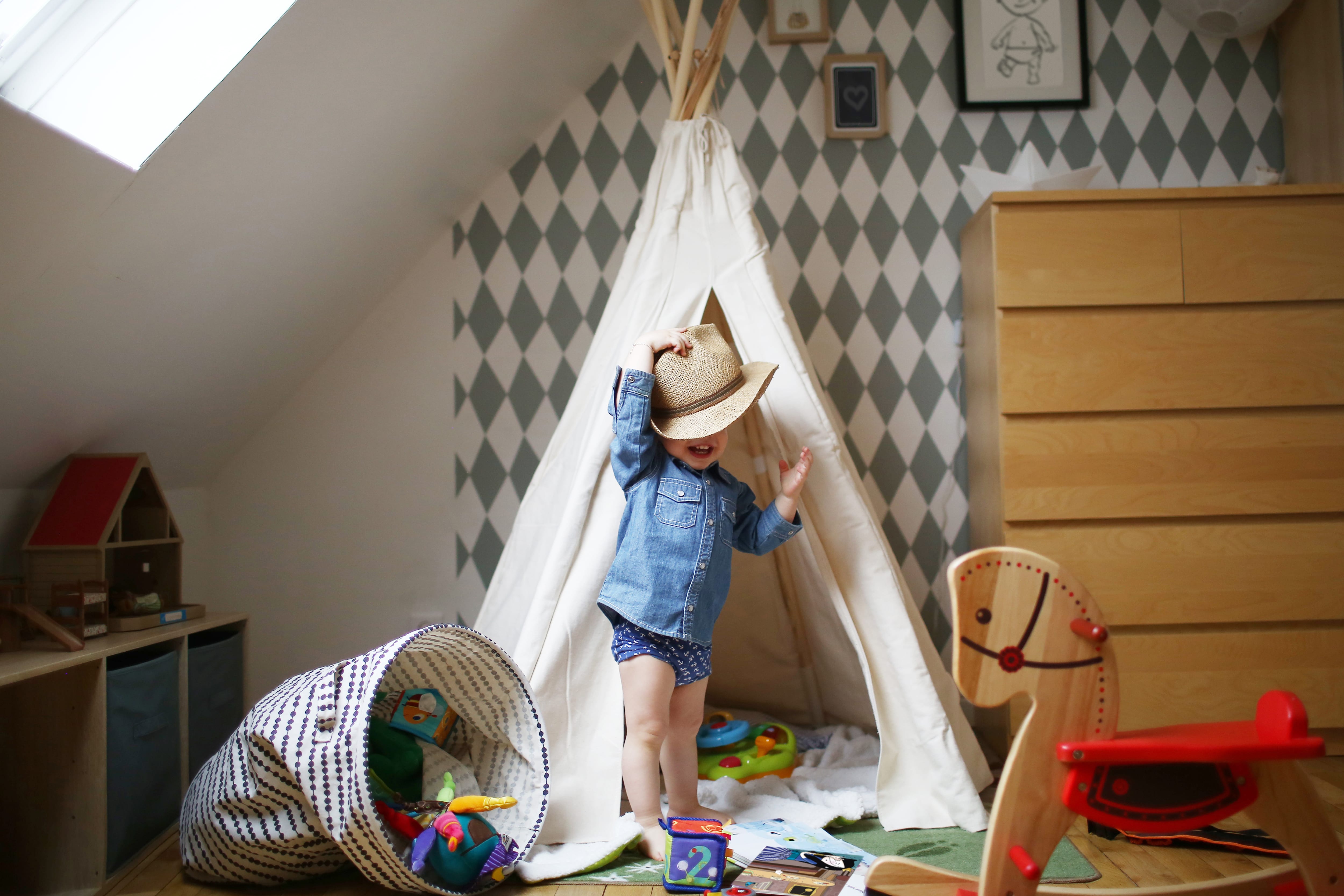 Child playing in room with checkered accent wall