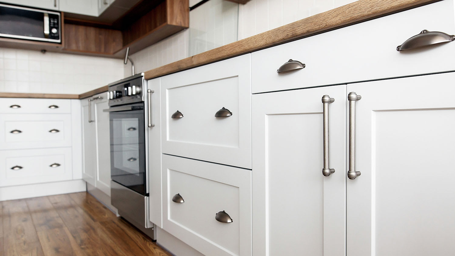 Silver kitchen hardware on white cabinets