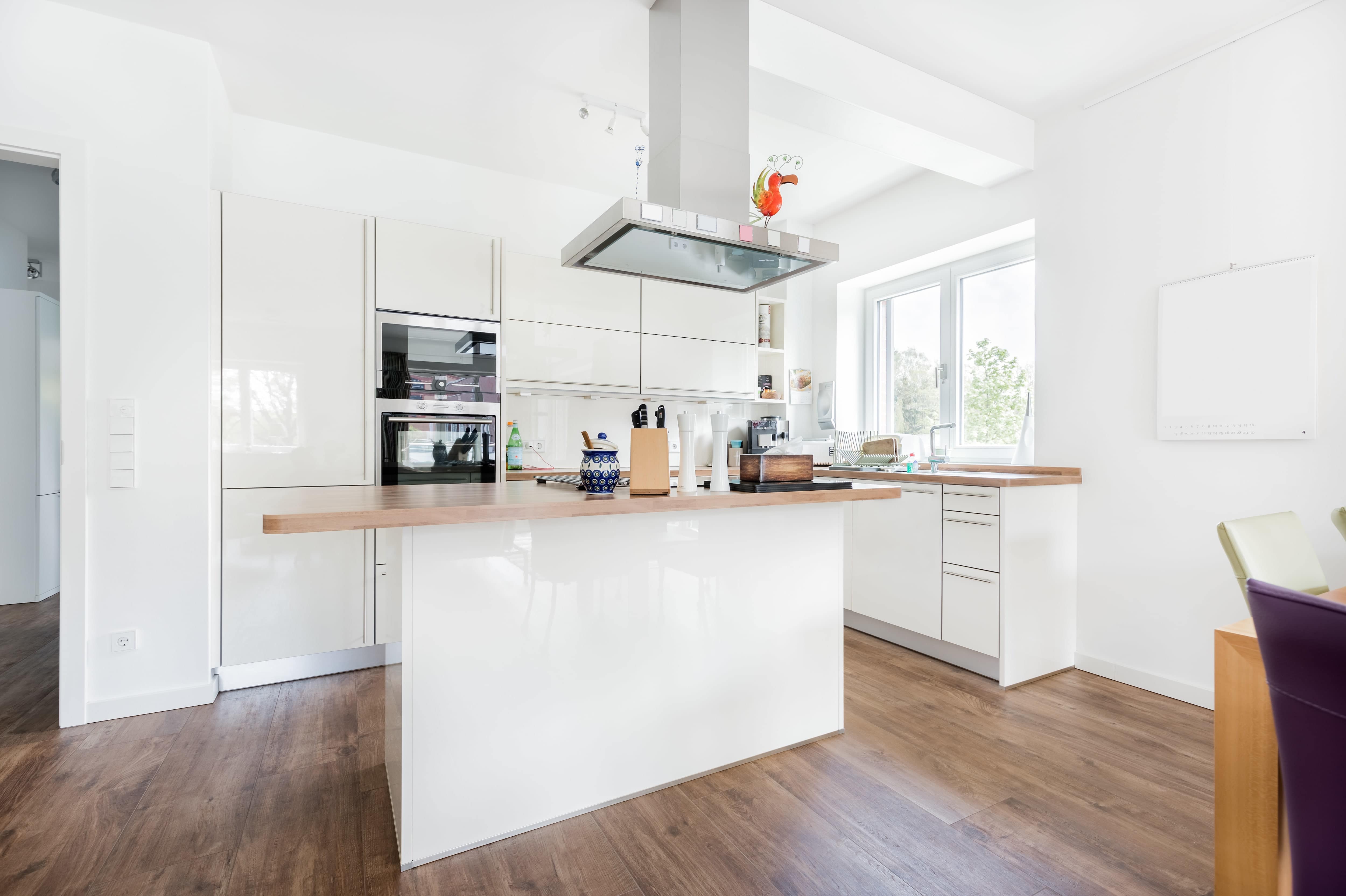 A bright kitchen with glossy cabinets and a kitchen island