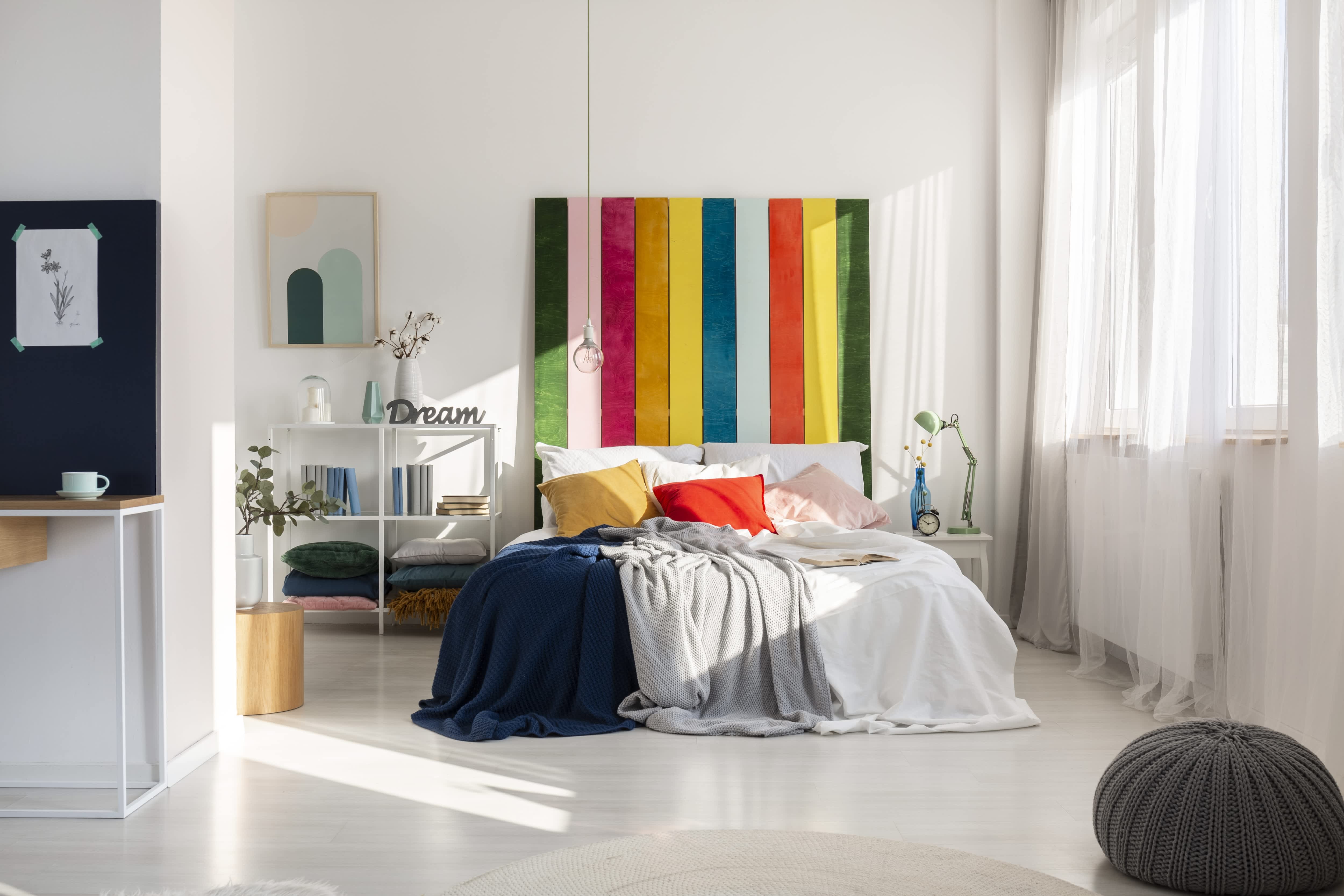 Colorful headboard in a bright, white bedroom with a comfy bed and pendant light