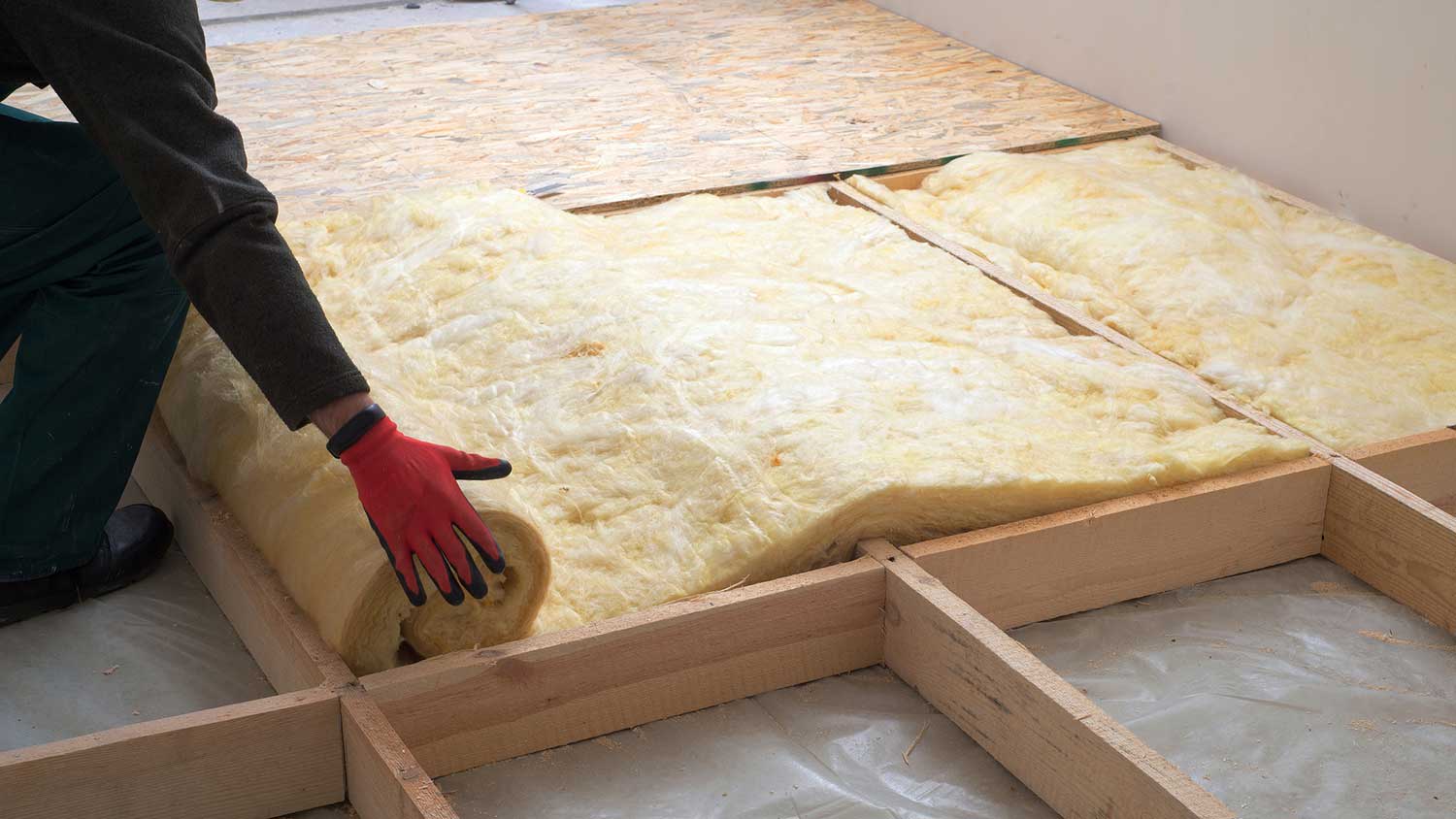 Handyman installing mineral wool floor insulation