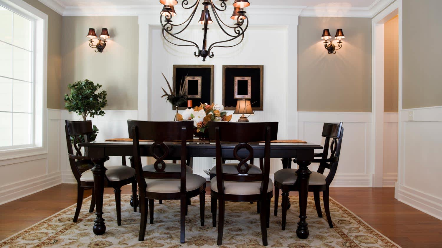 A formal dining room with white wainscoting