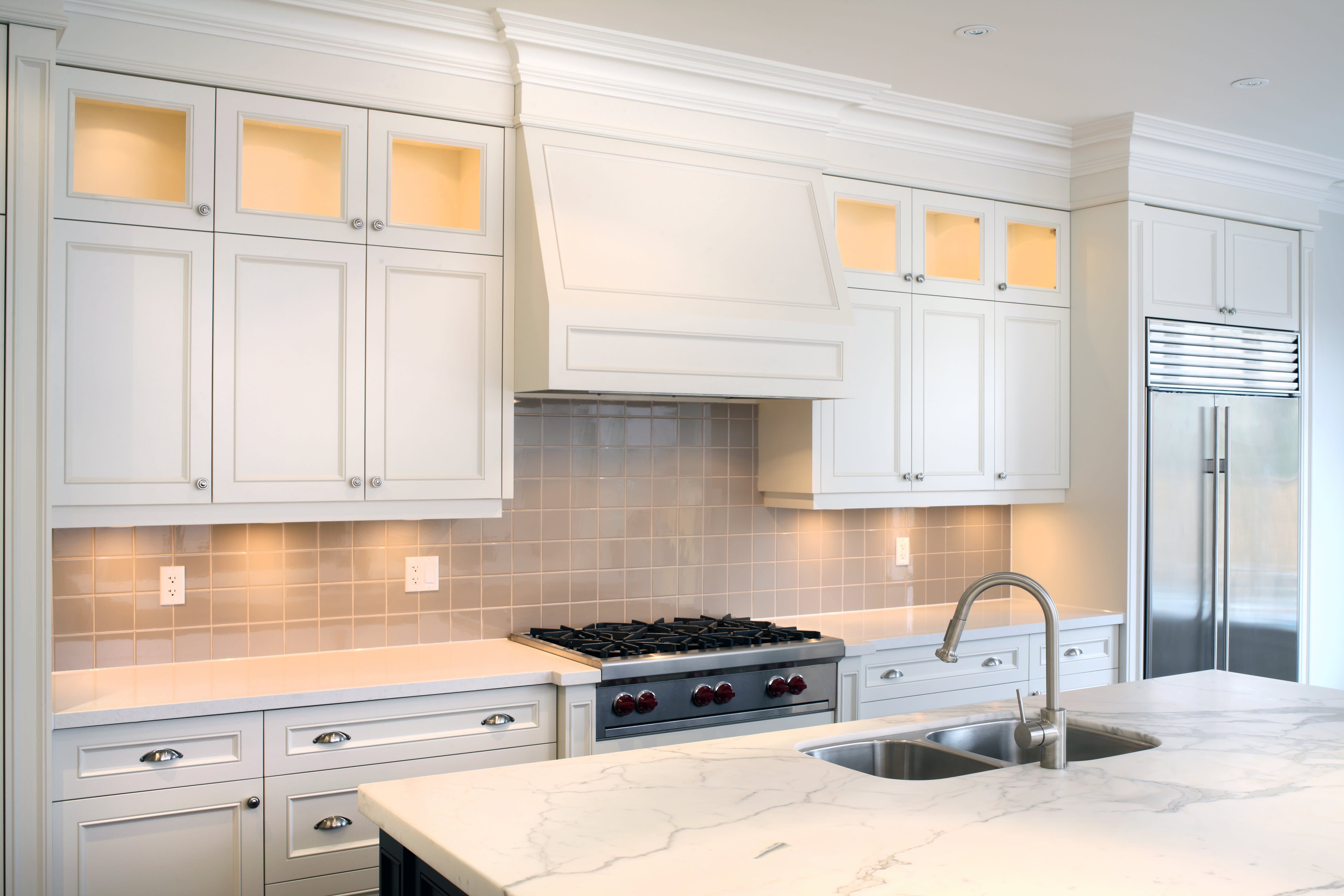 A modern white kitchen with marble countertops