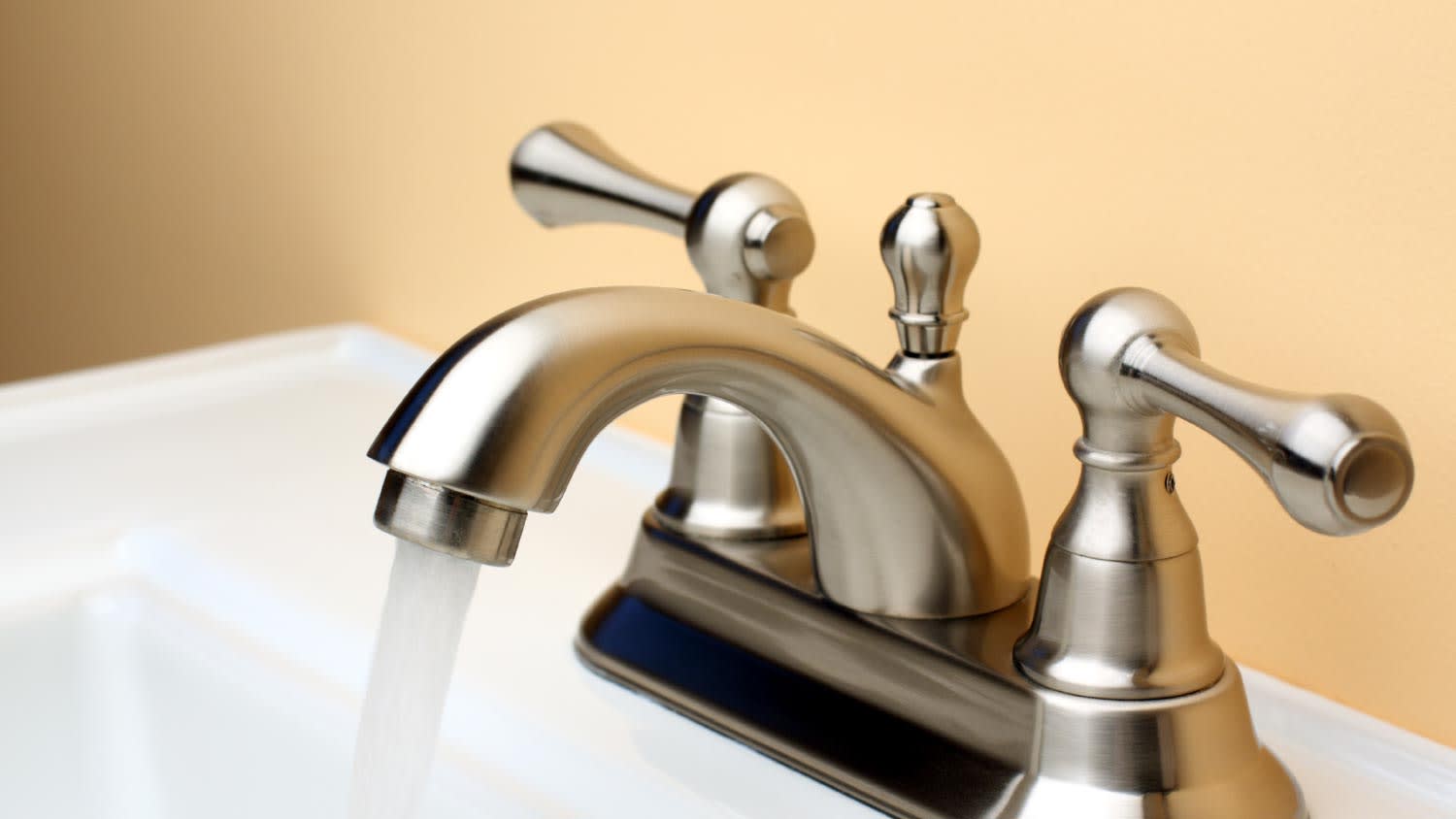 Water flowing from brushed nickel faucet