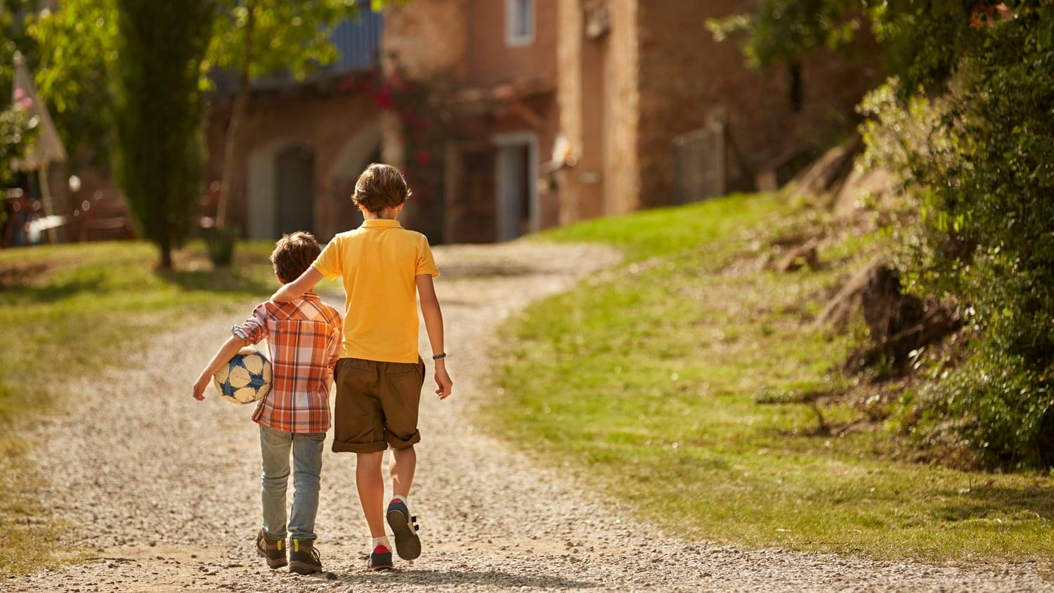 Siblings walking on a private road leading to their home