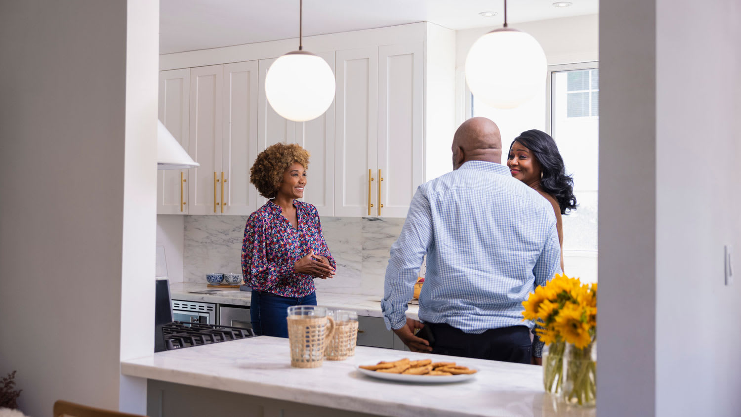 A realtor talking to a couple in their kitchen