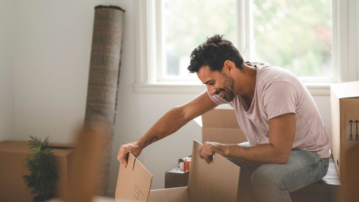 A man unpacking moving boxes