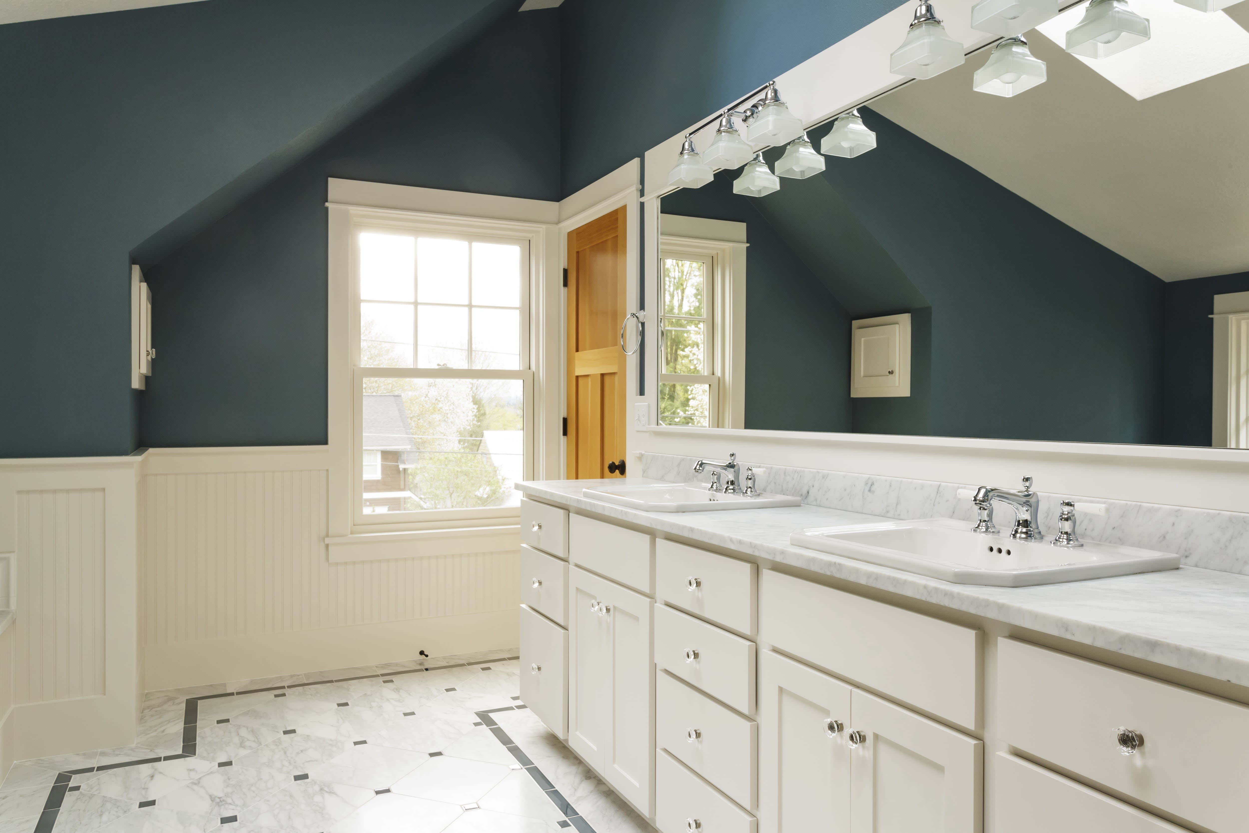 Dark green bathroom with marble double vanity and white beadboard