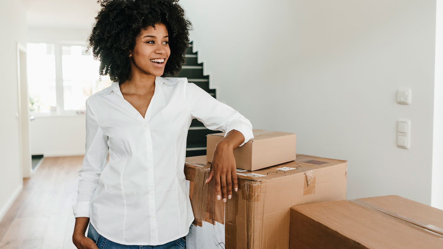 Smiling woman standing next to cardboard boxes
