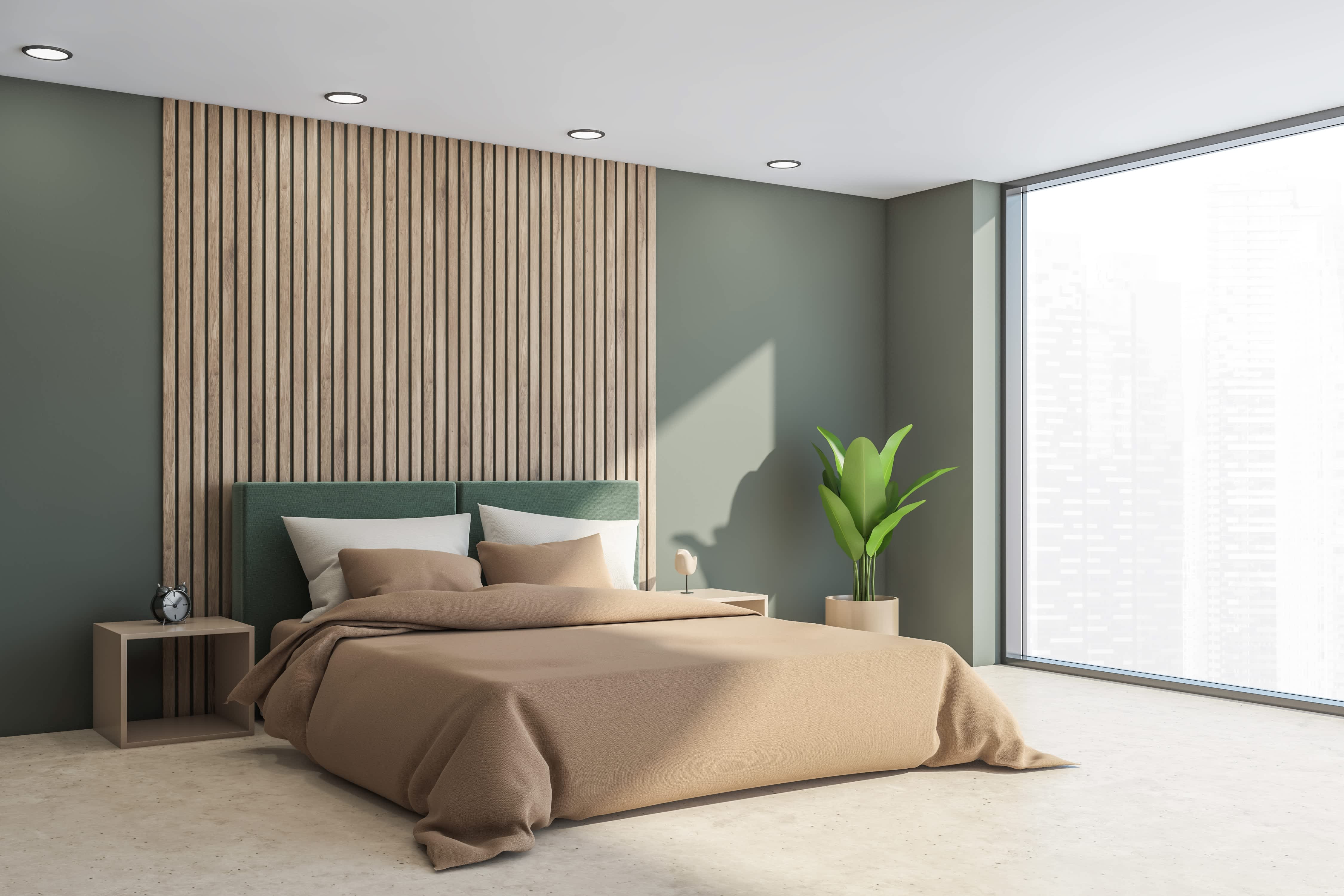 Bedroom with moss green walls and wood slat wall panel behind bed with tan bedding