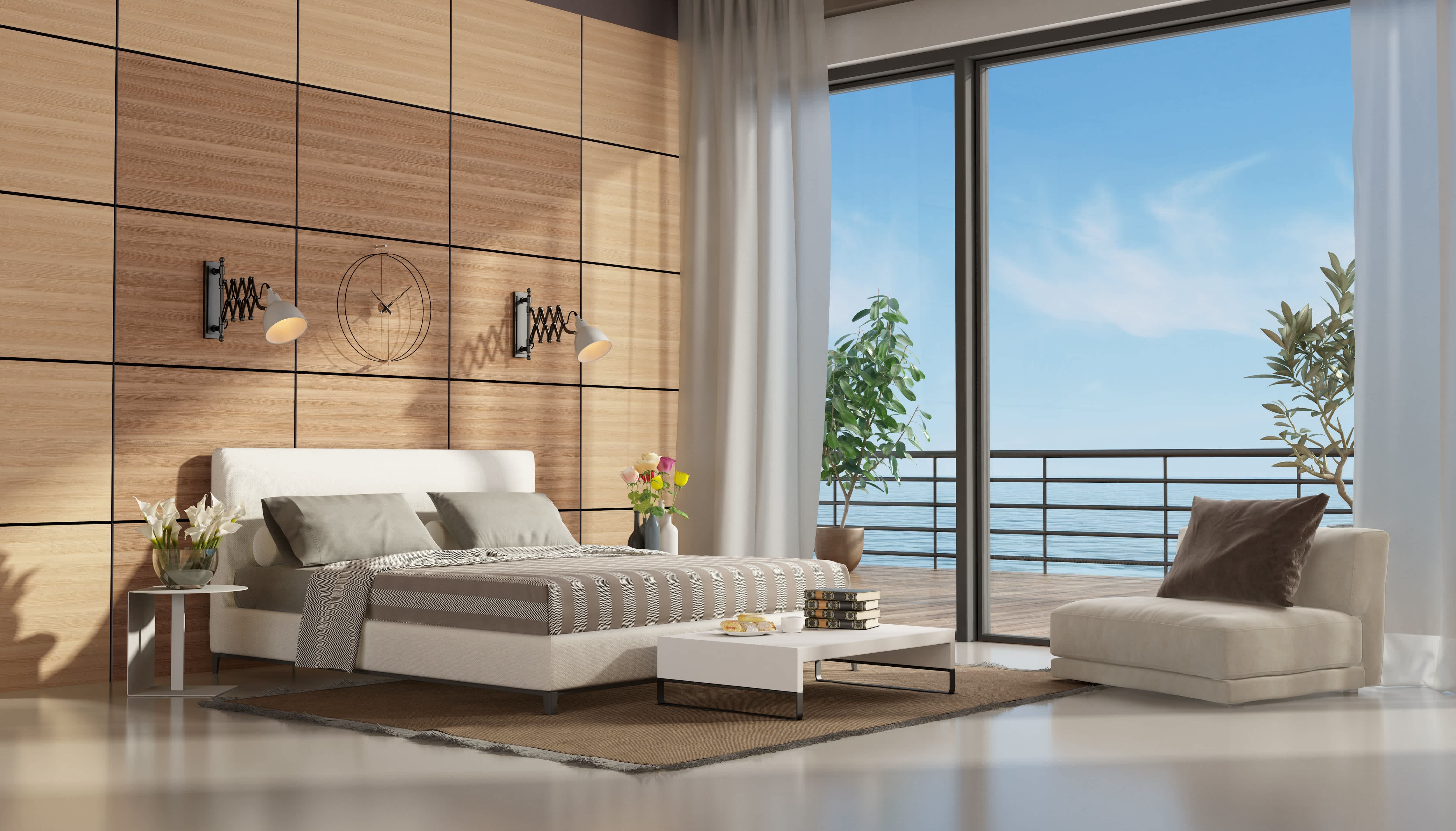 Primary bedroom with two-toned wood block wall panel behind modern white bed overlooking a bedroom terrace and the sea
