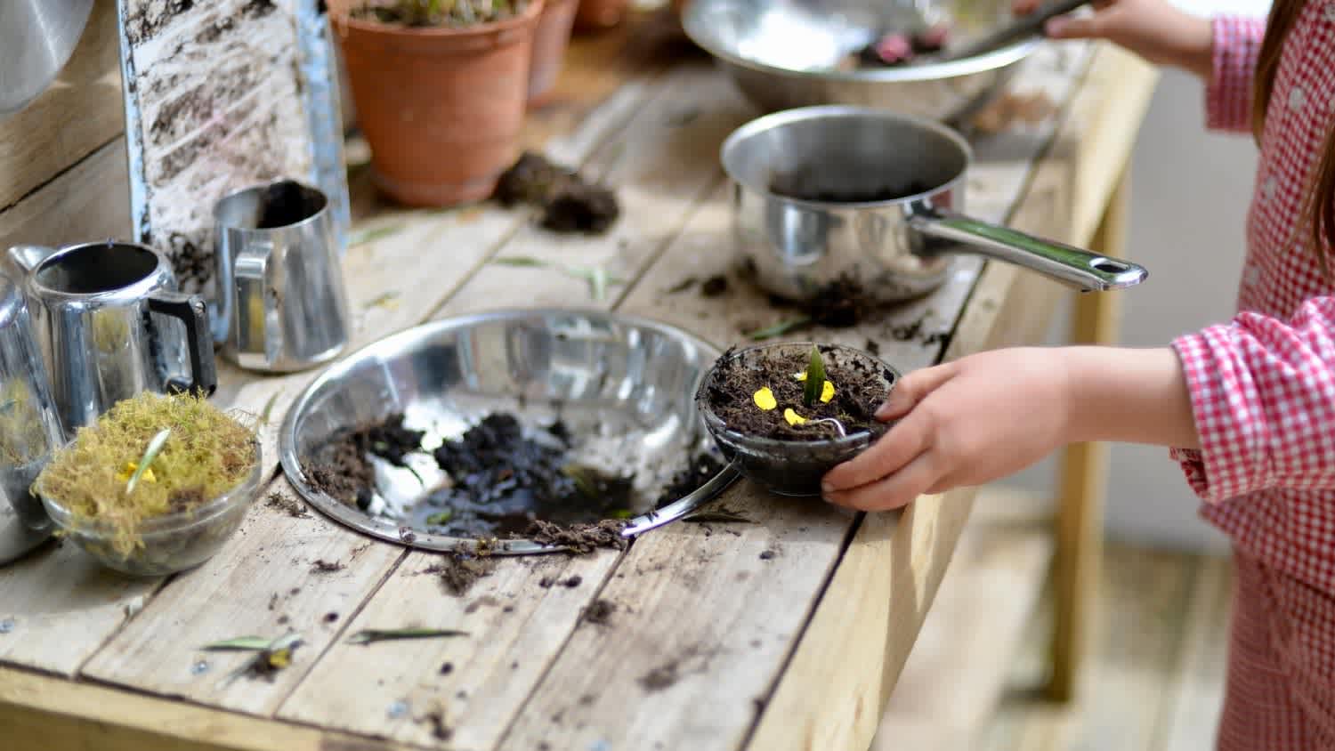 Mud kitchen made of wood with old kitchen utensils
