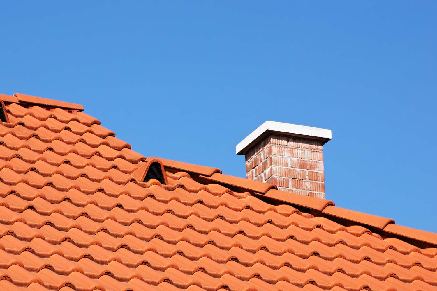 Detail of red tiled roof with chimney