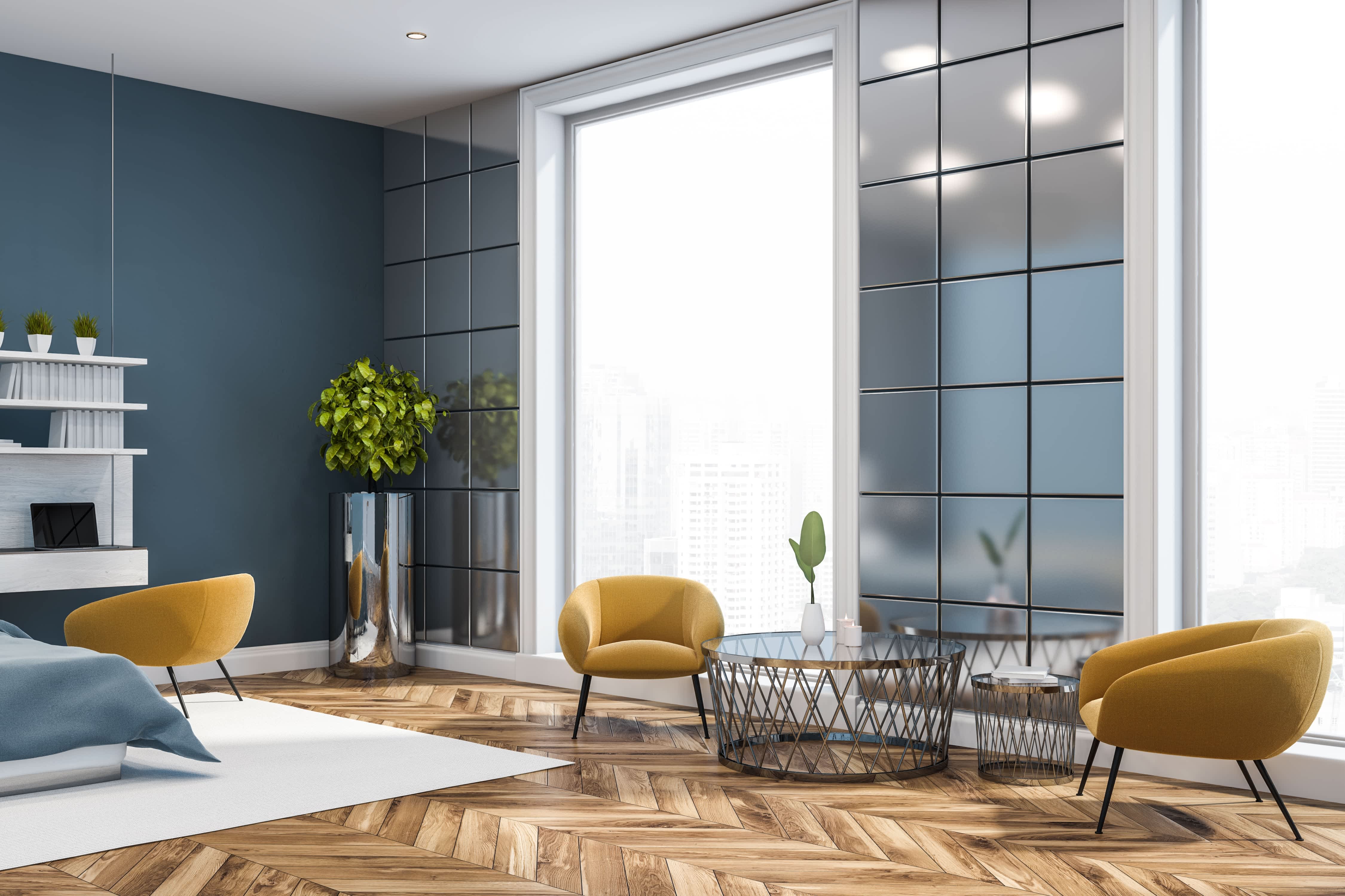 luxury living room with metal panel wall, chevron-patterned hardwood floor, and modern green chairs