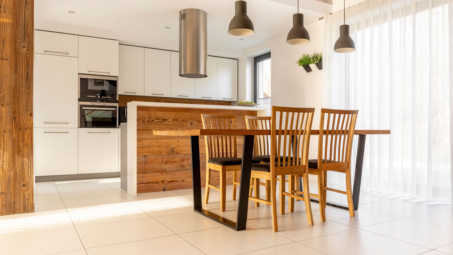 A bright kitchen with a dining table and tile flooring