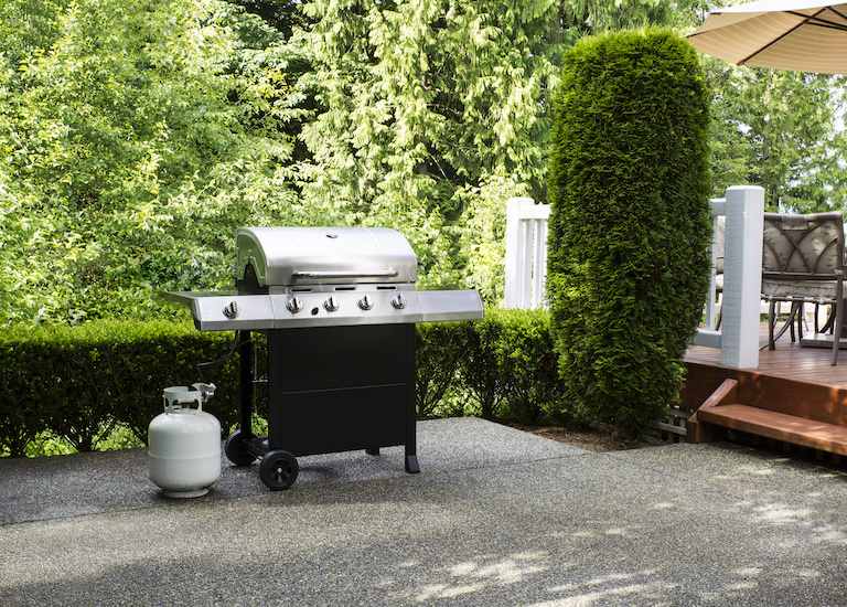 small propane tank and grill on concrete home patio
