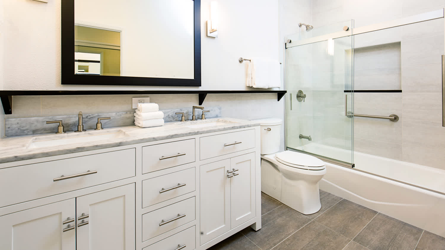 A contemporary bathroom with vanity and shower bathtub