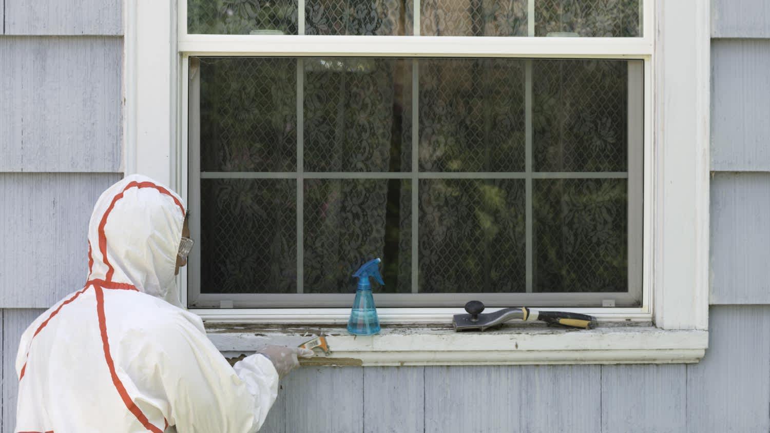 Worker removing exterior lead paint
