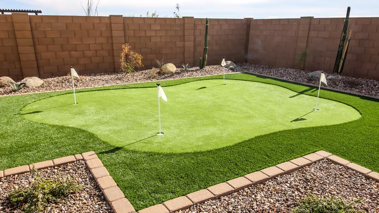 A four hole putting green in a house’s backyard
