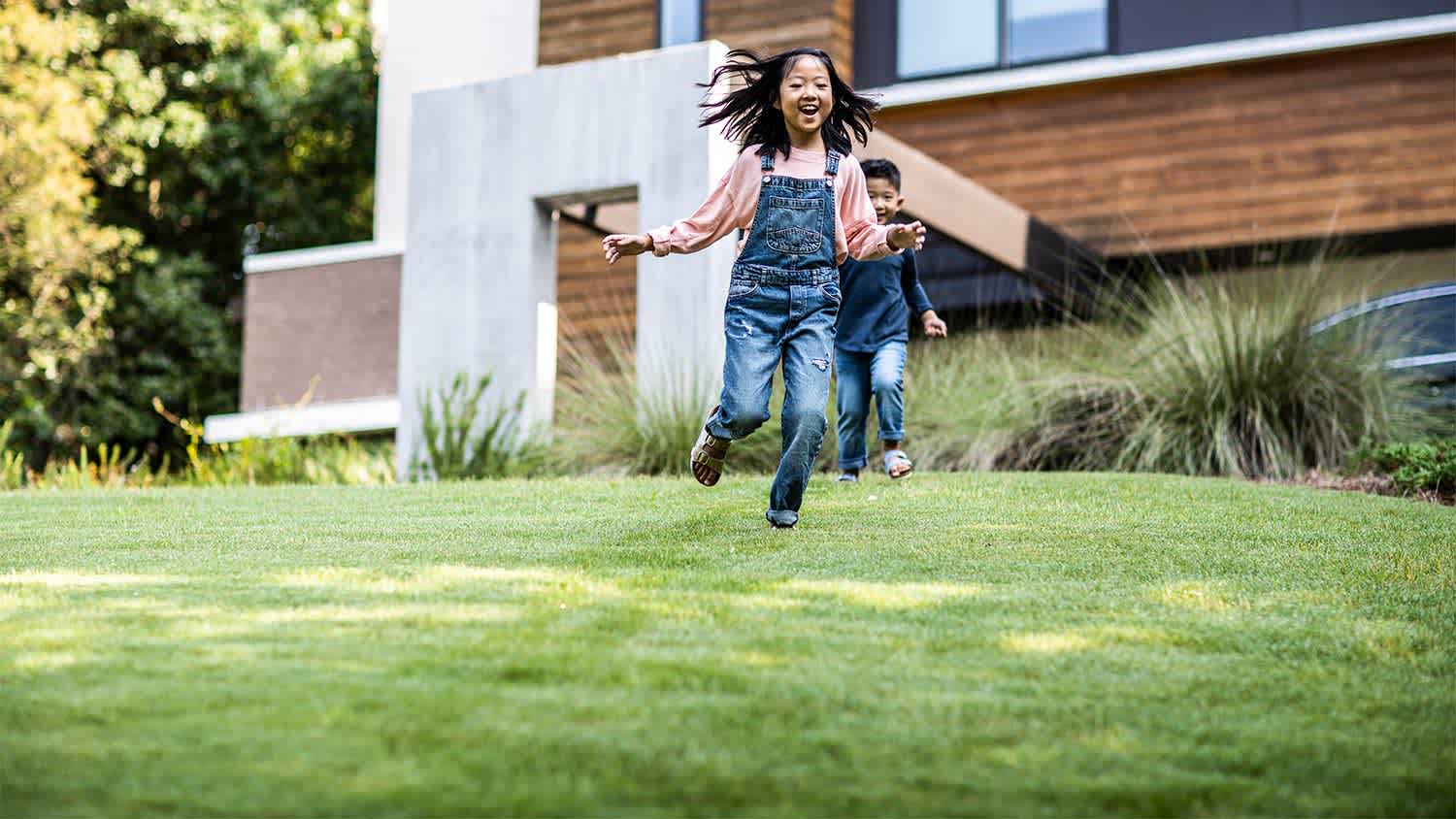 Kids running on grass lawn