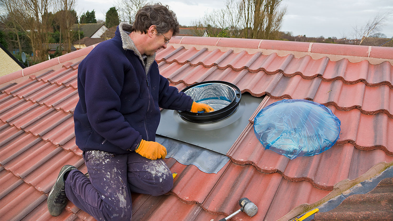 man installing sun pipe on roof