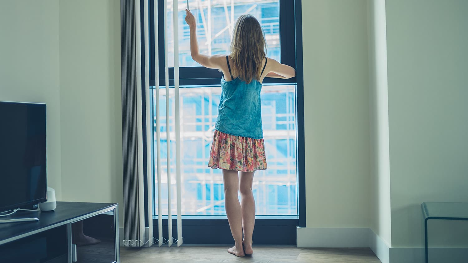 Woman closing blinds in apartment