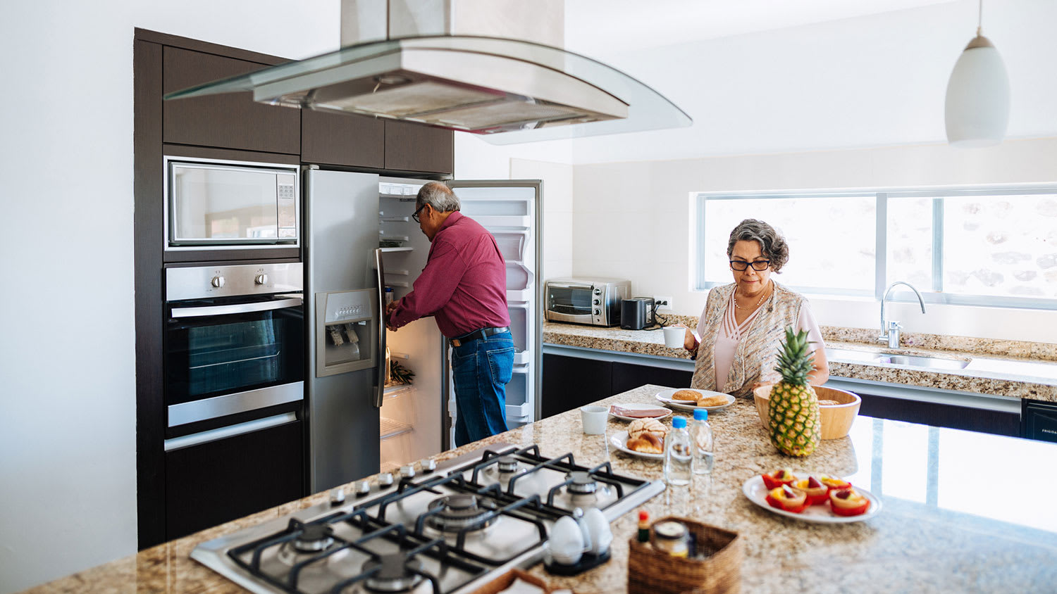 Senior couple in the kitchen making breakfast