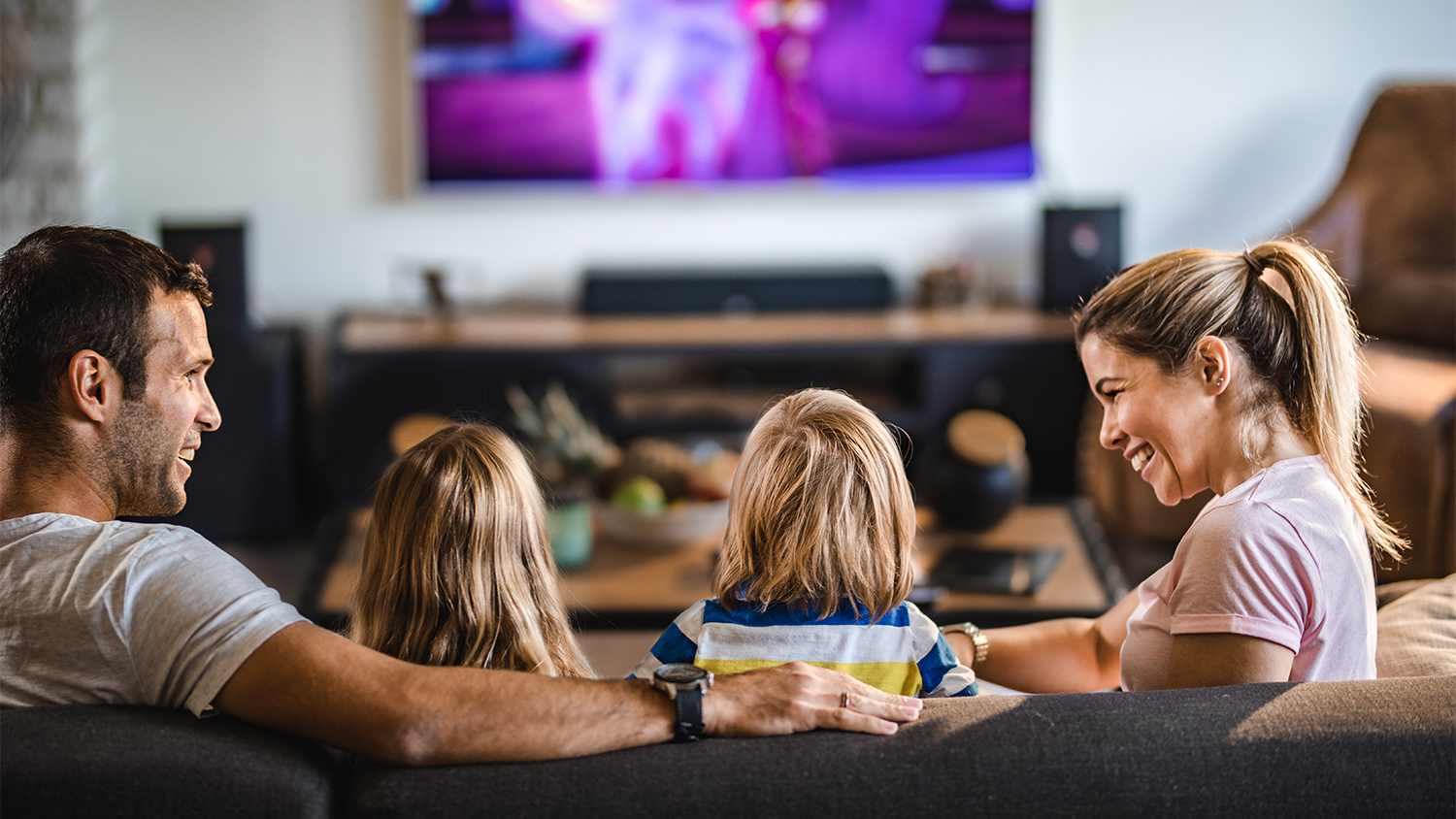 family at home watching tv in living room