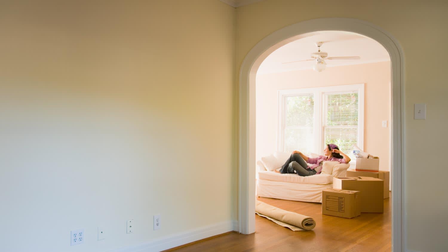 Woman sitting on sofa in new home