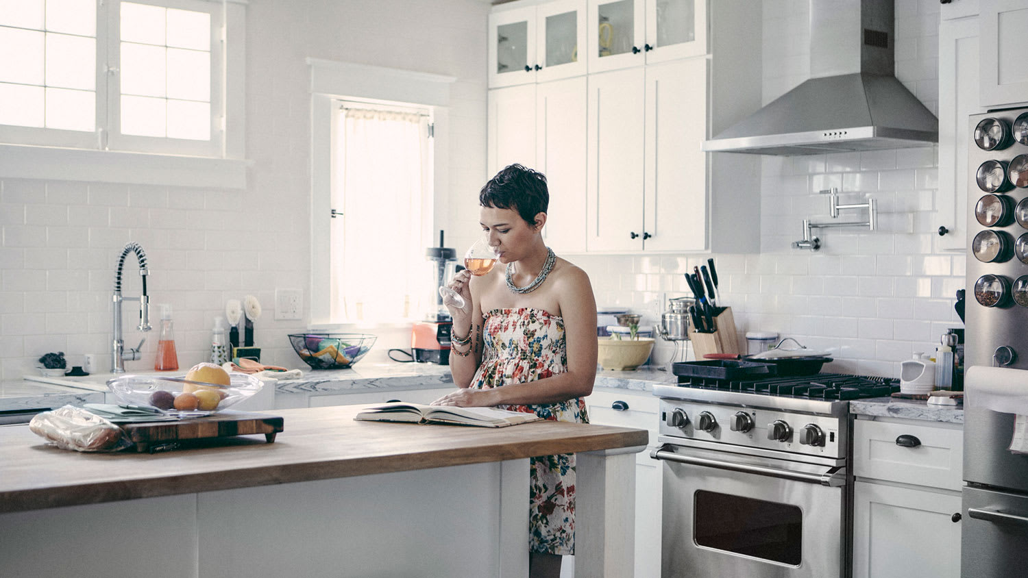 Woman in the kitchen reading a cookbook