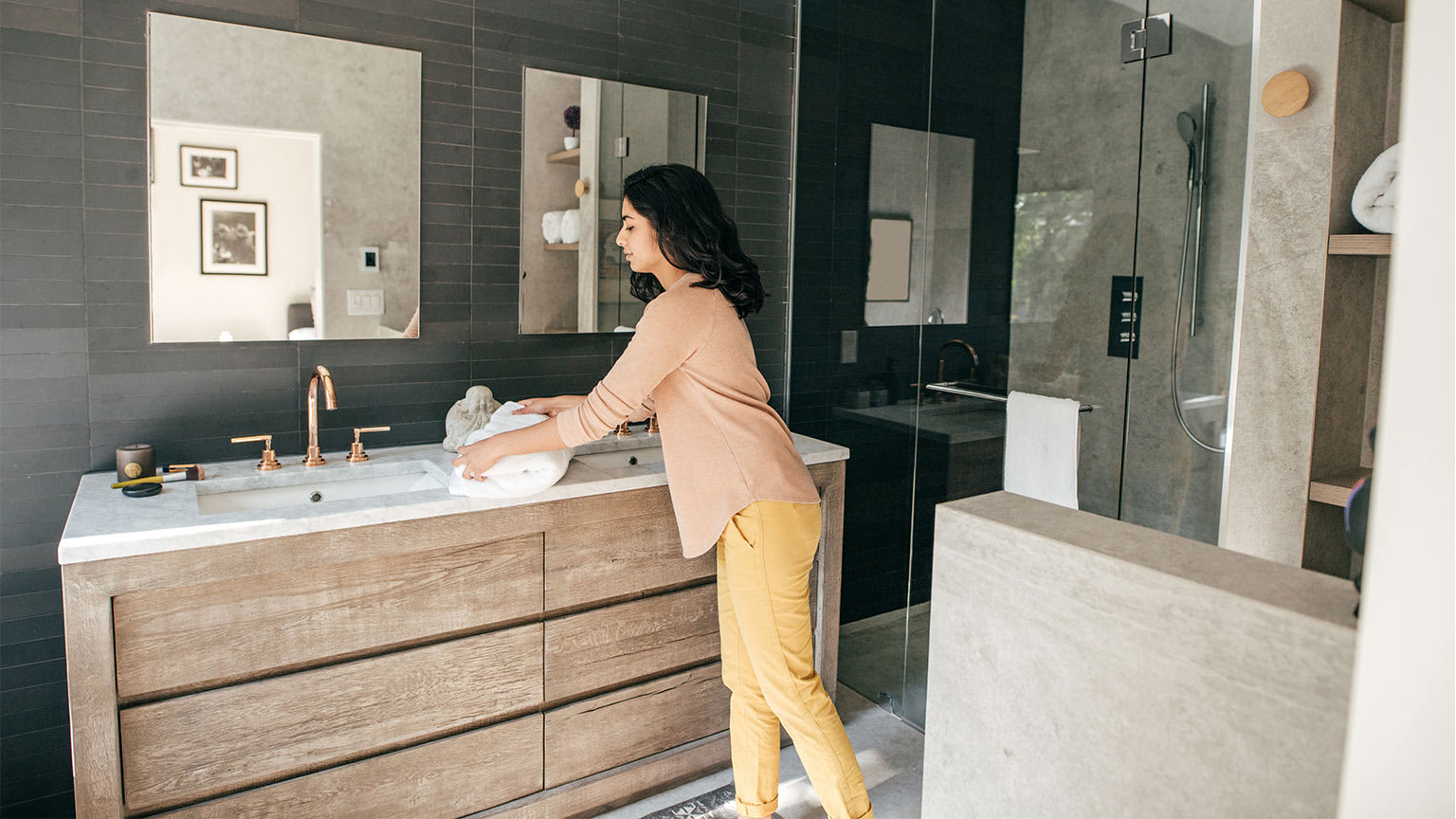 woman folding towels in luxury bathroom