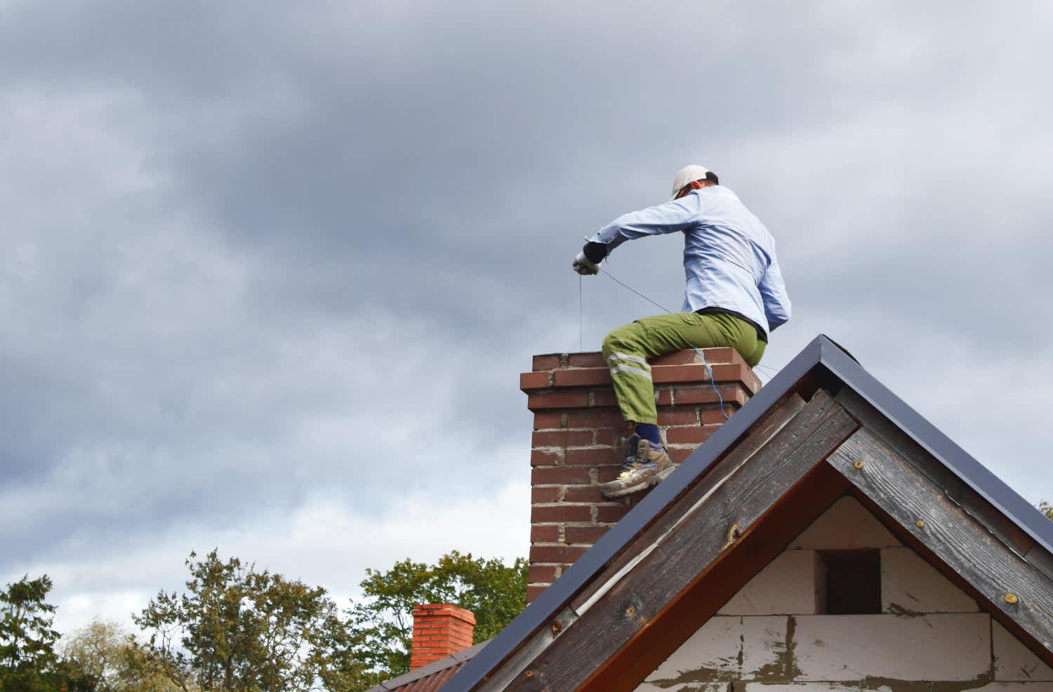 A chimney inspector sitting on chimney